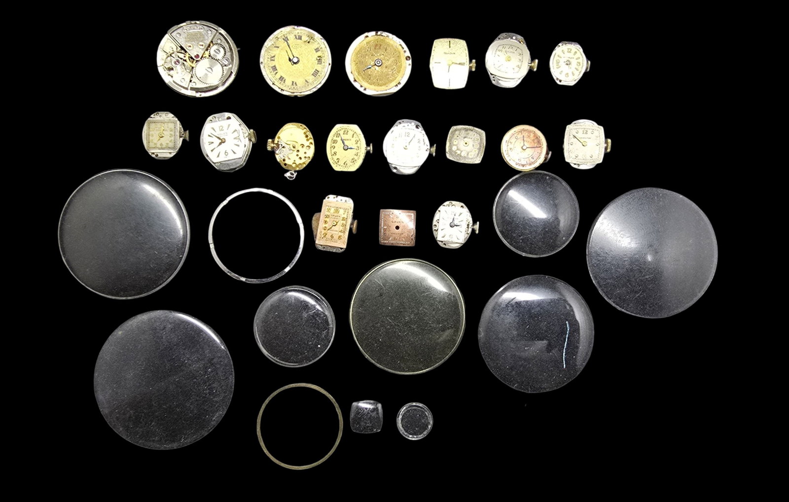 Lot of Watch Movements & Watch Glasses: Very good vintage condition with minor patina according to age. The largest piece measures approx. 1" high and 1" wide and the entire lot weighs ca. 69 grams.