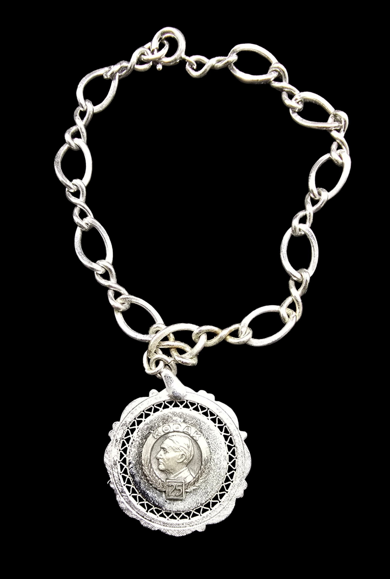 Beautiful Ornate Vintage Sterling Silver Kodak 25 Years Anniversary Pendant Bracelet: Good vintage condition w/ patina and wear according to age and use, see pictures. Weighs ca. 12 grams. Measures approx. 9" high , 1" wide. Marked Sterling Silver