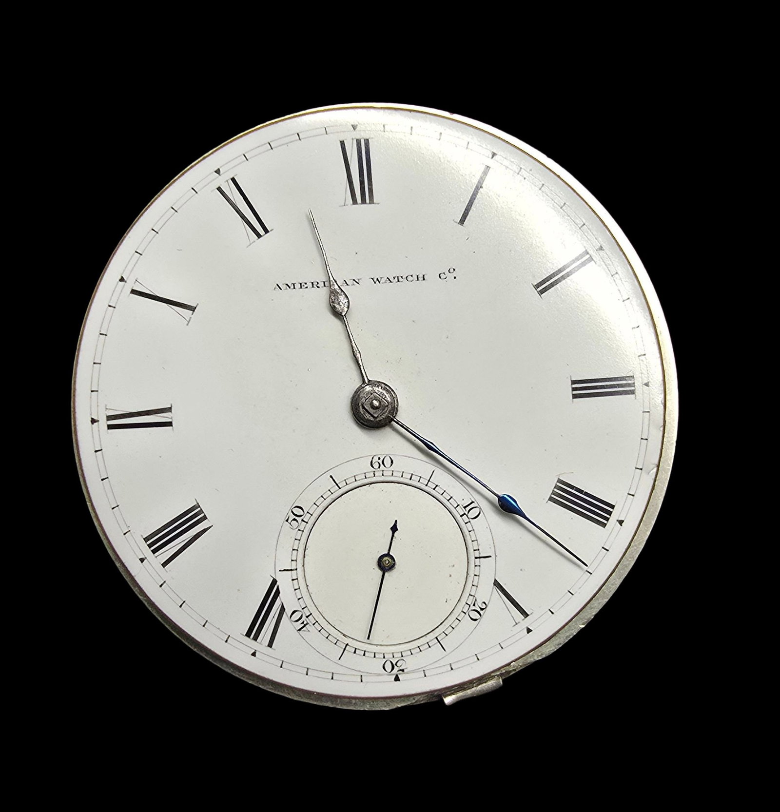 AMERICAN WATCH COMPANY Watch Movement w/ White Dial: Good vintage condition w/ minor patina according to age. The frame is loose. Measures approx. 2" high and 2" wide and weighs ca. 64 grams.