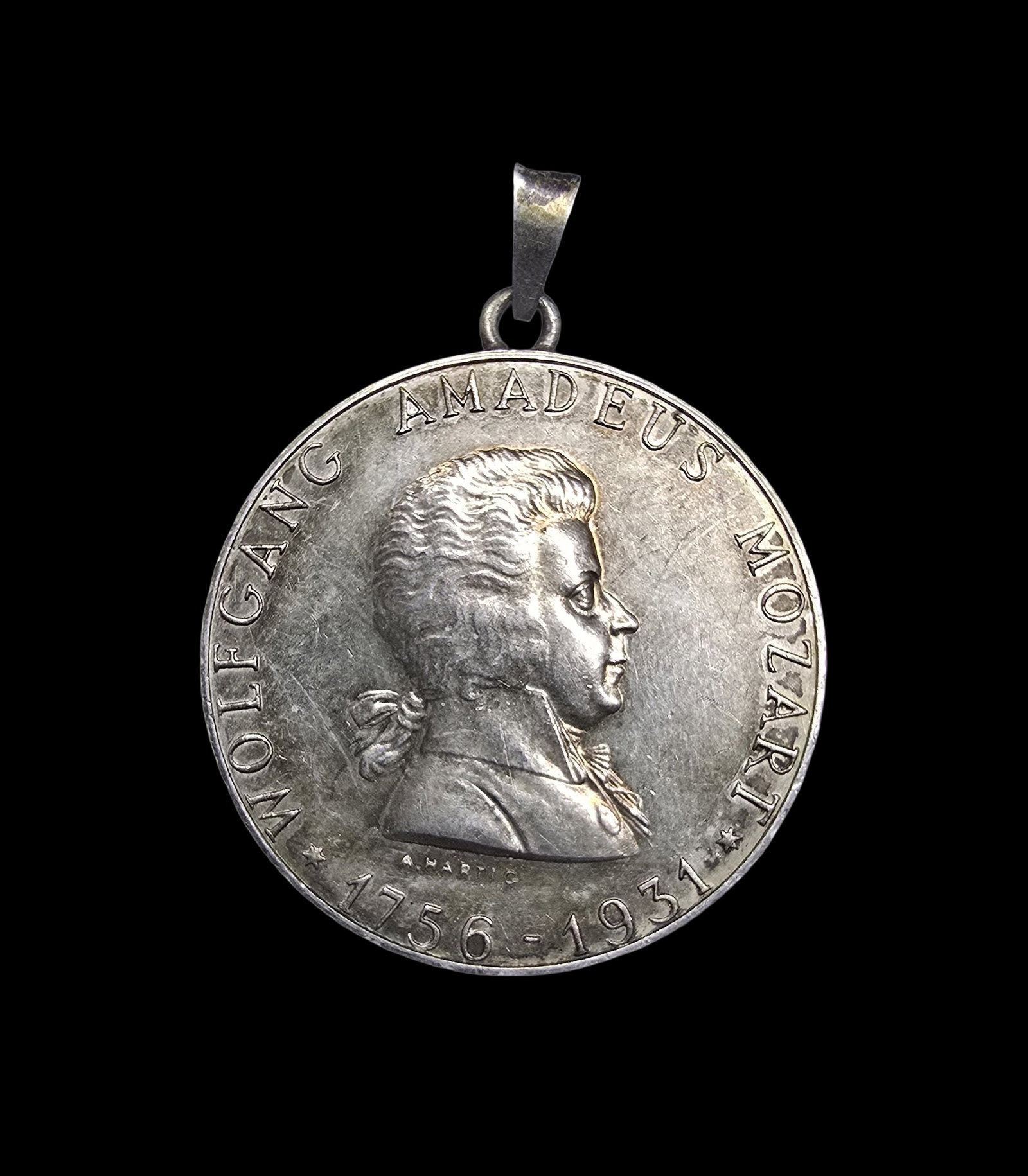Amazing Vintage 1931 Wolfgang Amadeus Mozart 640 Silver Coin Pendant: Very good antique condition with minor patina according to age. Measures approx. 1 1/2" wide and weighs ca. 20 grams. Coin is 640 silver; loop and bale are also silver.