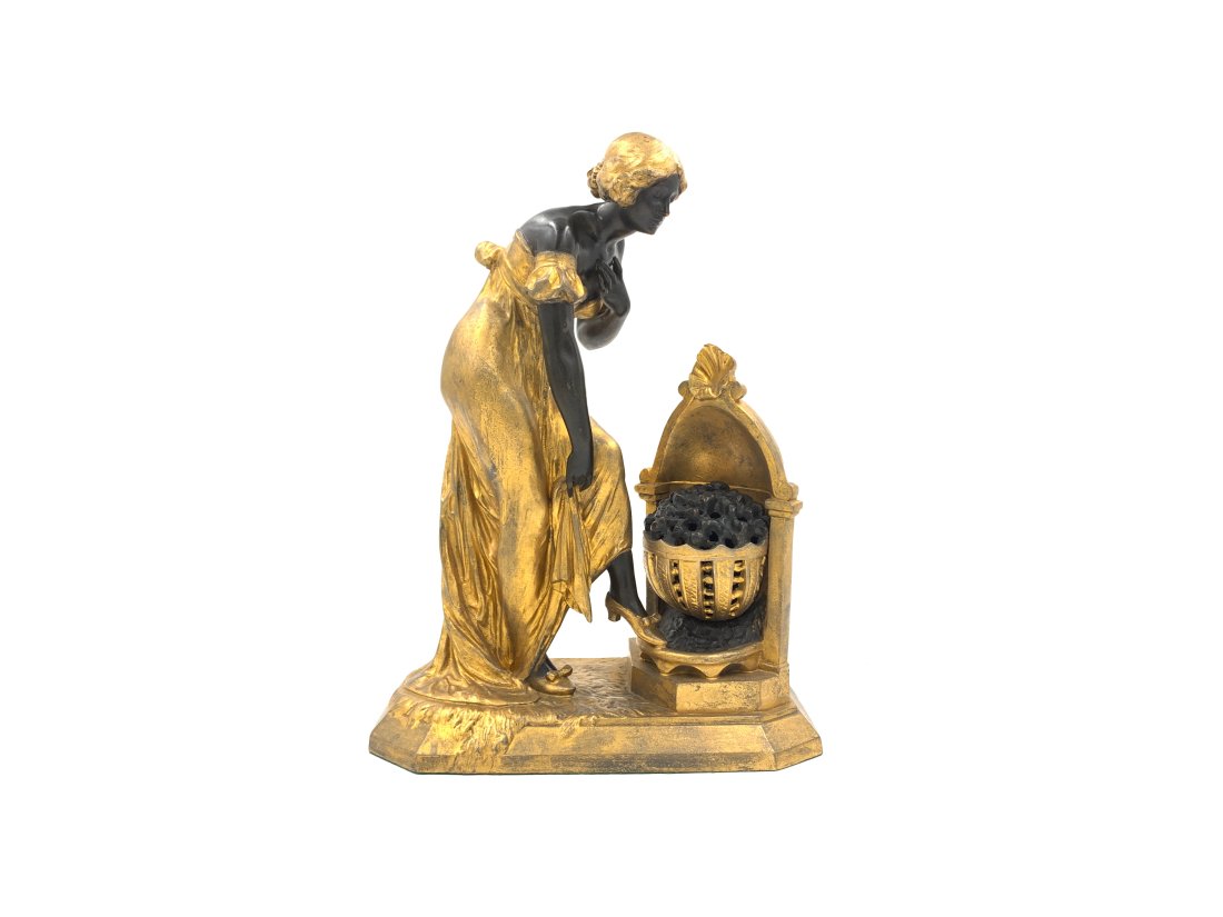 GILDED METAL FIGURAL LAMP AFTER JULES CAUSSE, (FRENCH, 1869-1914): A Late 19th/early 20th Art Nouveau figural spelter lamp after Julien Causse (French, 1869-1914) "Frileuse," depicting a female standing at a hearth warming her feet, signed "J. Causse" on base verso a