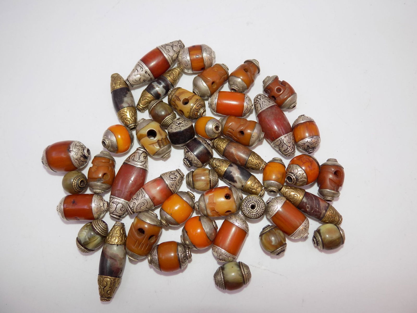 Antique Tibetan Silver Capped Beads: Antique Tibetan Silver Capped Beads, Assortment includes Carnelian, Amber and more, 45 Beads. Measurements: Beads range in size from 3/4" to 1 3/4" each, Weight: 9.2 OZ.