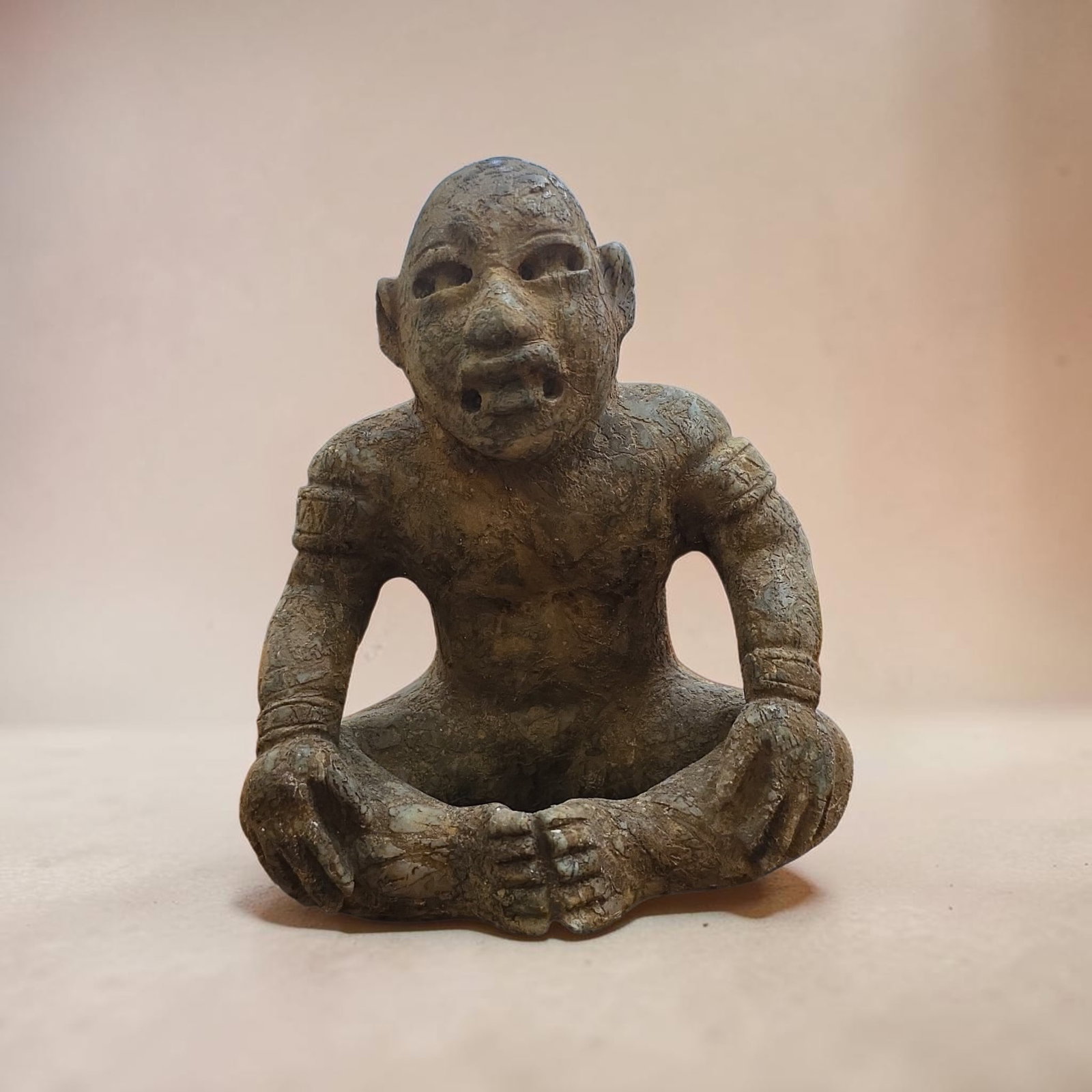 Pre-Columbian Olmec Seated Figure: 5.75" x 5" Pre-Columbian Olmec Seated Figure, Heavy Patina, Carved Green Stone, Almond Shaped Eyes, Down-Turned snarl mouth, Transformation seated figure, Cross-legged stance with hands resting on kne