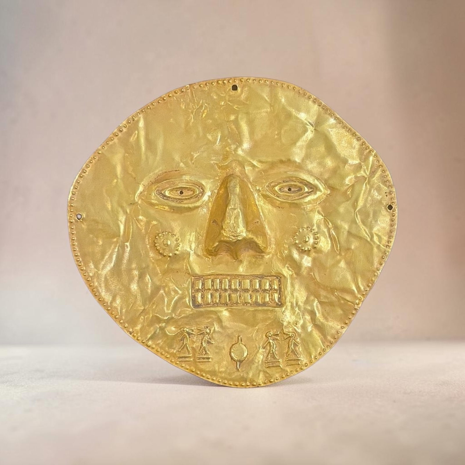 Authentic Pre-Columbian Colima Gold Funerary Mask: 5.5" x 5.5" Pre-Columbian Colima Gold Funerary Mask, High Karat Gold, Hammered Sheet Repousse Gold Depicts anthropomorphic features, prominent triangular nose, stylized eyes, decorative circular ear o