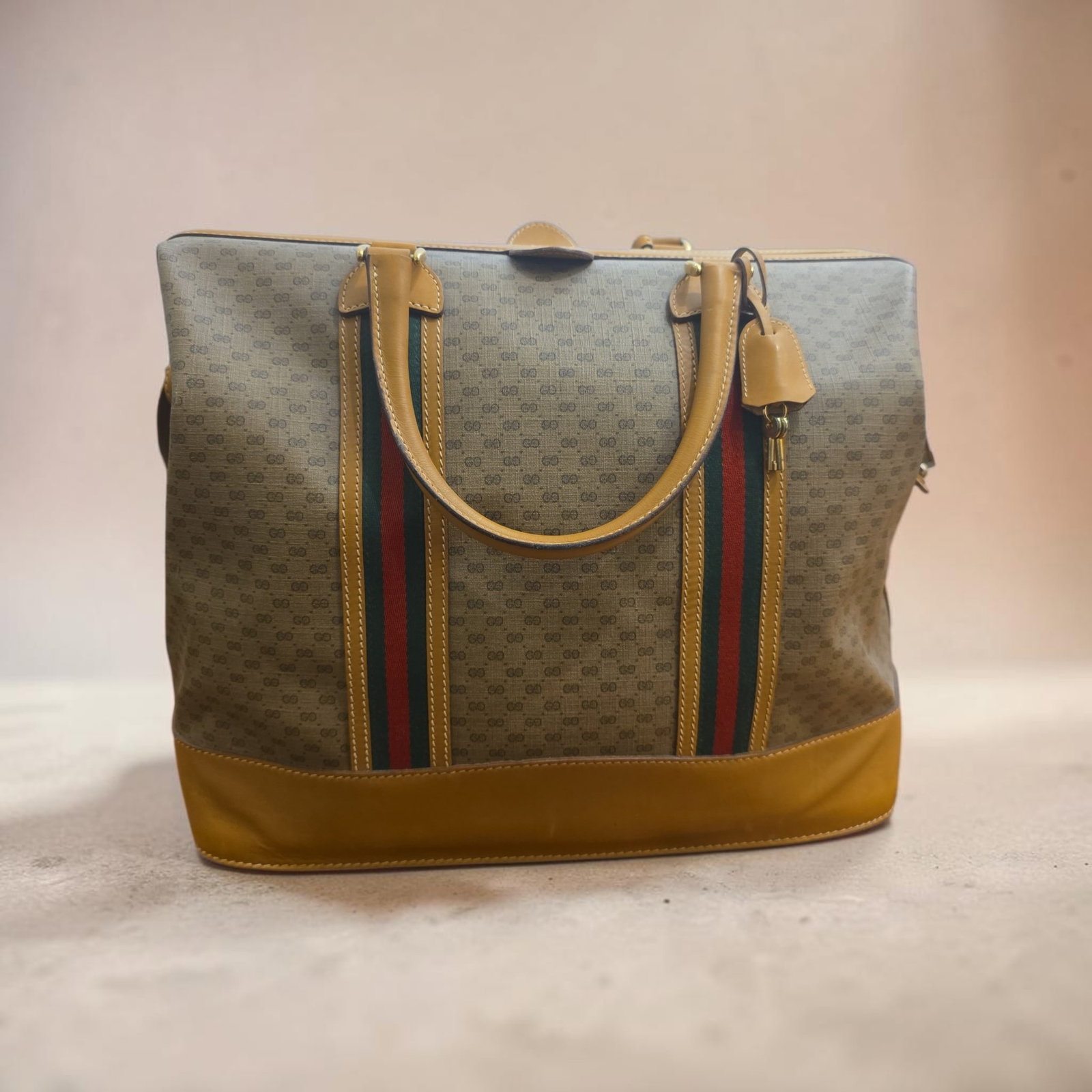 Authentic vintage Gucci Micro-GG Sherry Line travel/Boston bag: 21.3" x 15.75" Authentic vintage Gucci Micro-GG Sherry Line travel/Boston bag, Micro-GG monogram coated canvas with structured mustard-tan leather base and double handles, features the iconic green
