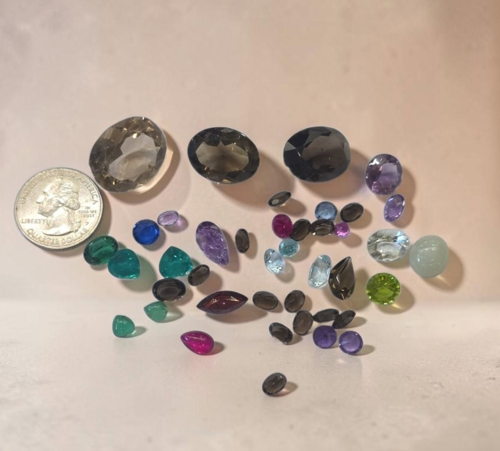 Assortment of loose, faceted, and smooth cabochon semi-precious and colored gemstones (1 of 2)