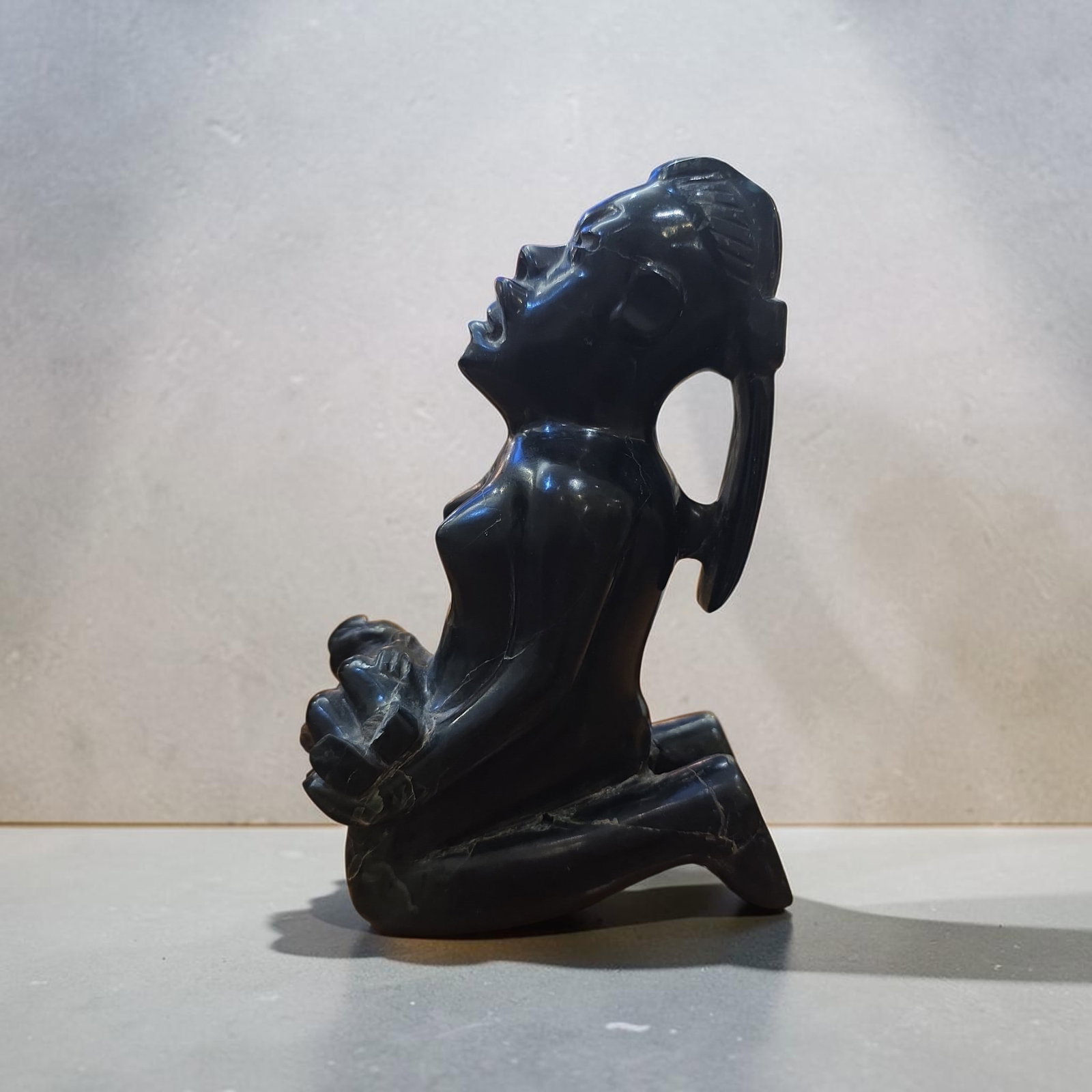 Pre-Columbian Olmec Jade Seated Transformation Figure with Child: 7" x 2.25", Pre-Columbian Olmec Jade Seated Transformation Figure with Child, Kneeling Female with Were-Jaguar Features Holding an Infant, Dark Jade Stone, High Polish, Mineral Deposits, Olmec