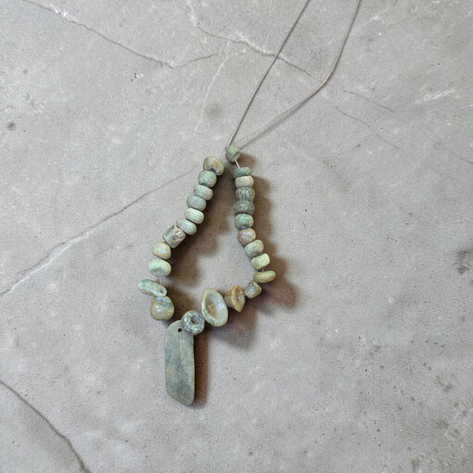 Pre-Columbian Mayan Jade Beads: 9" Strand, Pre-Columbian Mayan Jade Bead Assortment, High Polish Translucent Jade Beads, Mesoamerica, 300-800 C.E. , Approximately 9" Strand of Beads with Long Jade Celt