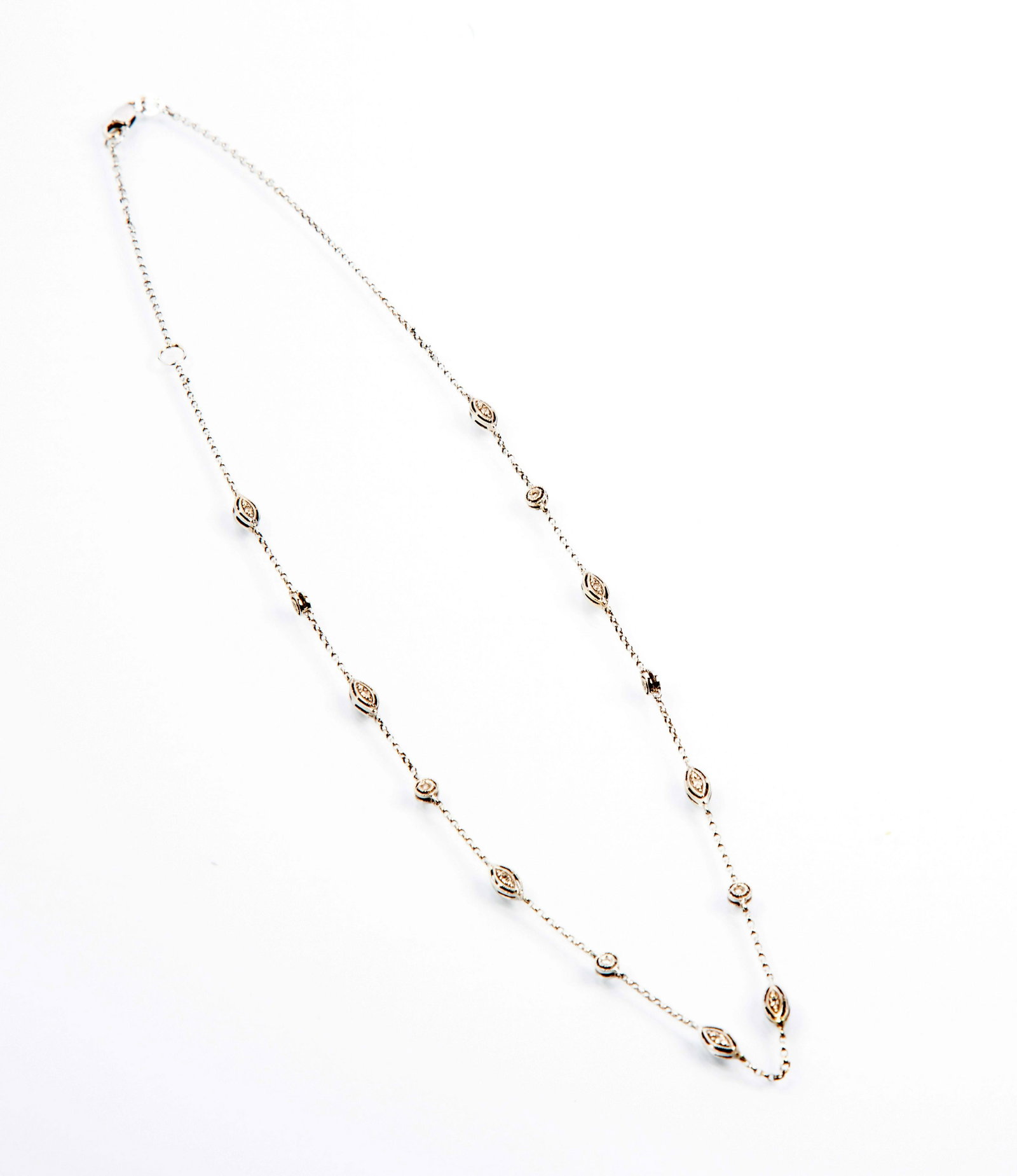 White Gold Milgrain Diamond Station Necklace: White Gold Milgrain Diamond Station Necklace, marked on clasp 14k, round and oval alternation stations with milgrain edges and each with a small diamond, the stations are double sided, the necklace ap