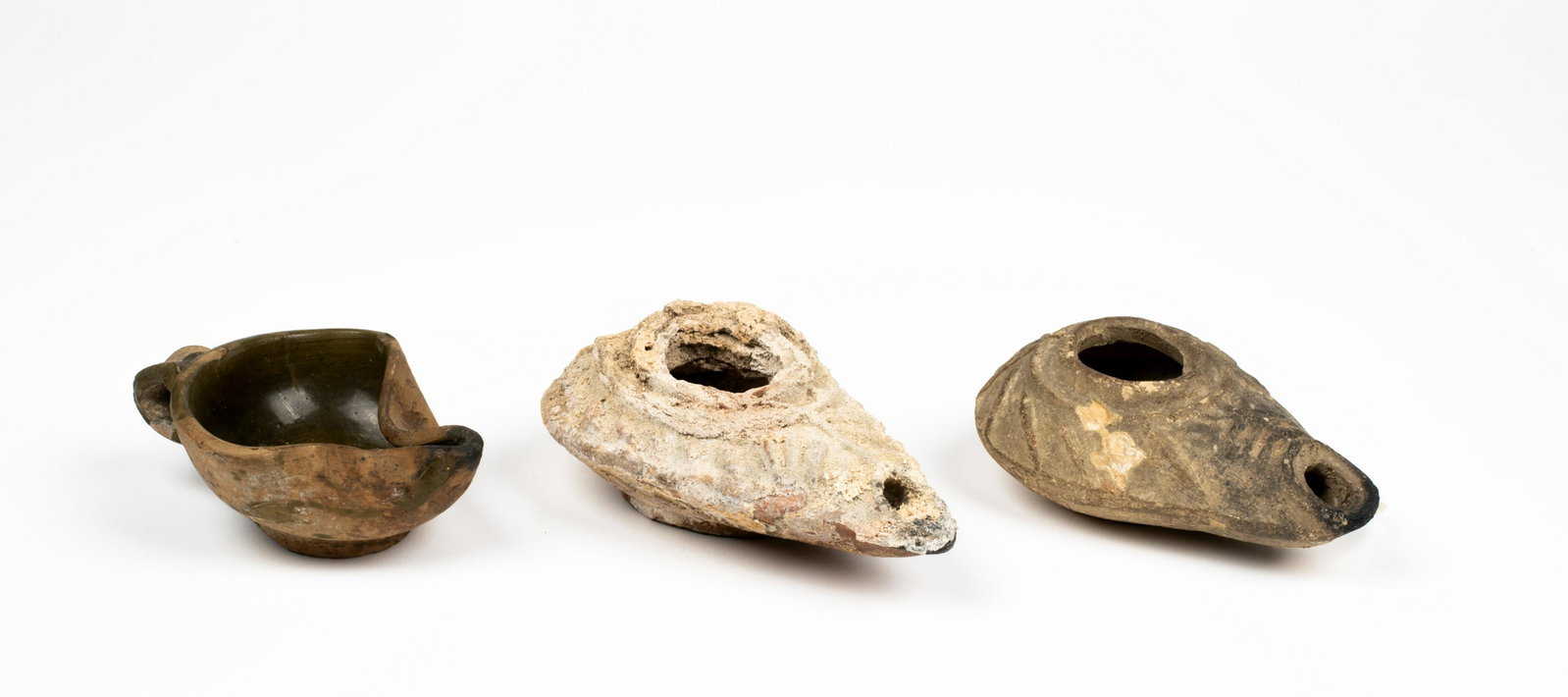 Three Palestine/Near East Oil Lamps: Three Palestine/Near East Oil Lamps; the largest of light clay, with paper stating that it was collected by Herbert Clark in Jerusalem in 1912; the second from the same period (100BC-100AD) and of the
