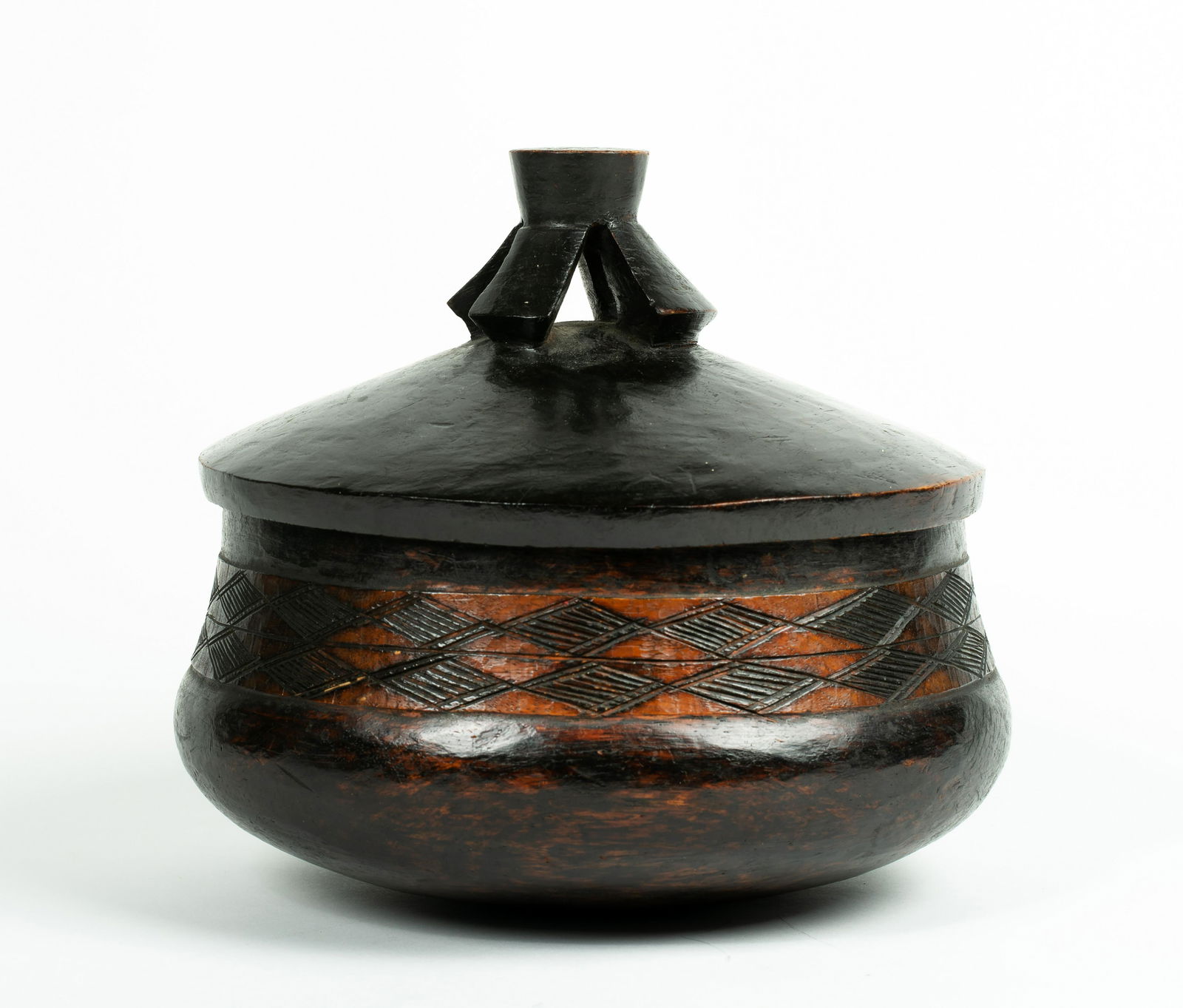 A Central African Wooden Lidded Vessel: A Central African Wooden Lidded Vessel, with a band of incised geometric designs around, and flared top knop. Diameter 9"