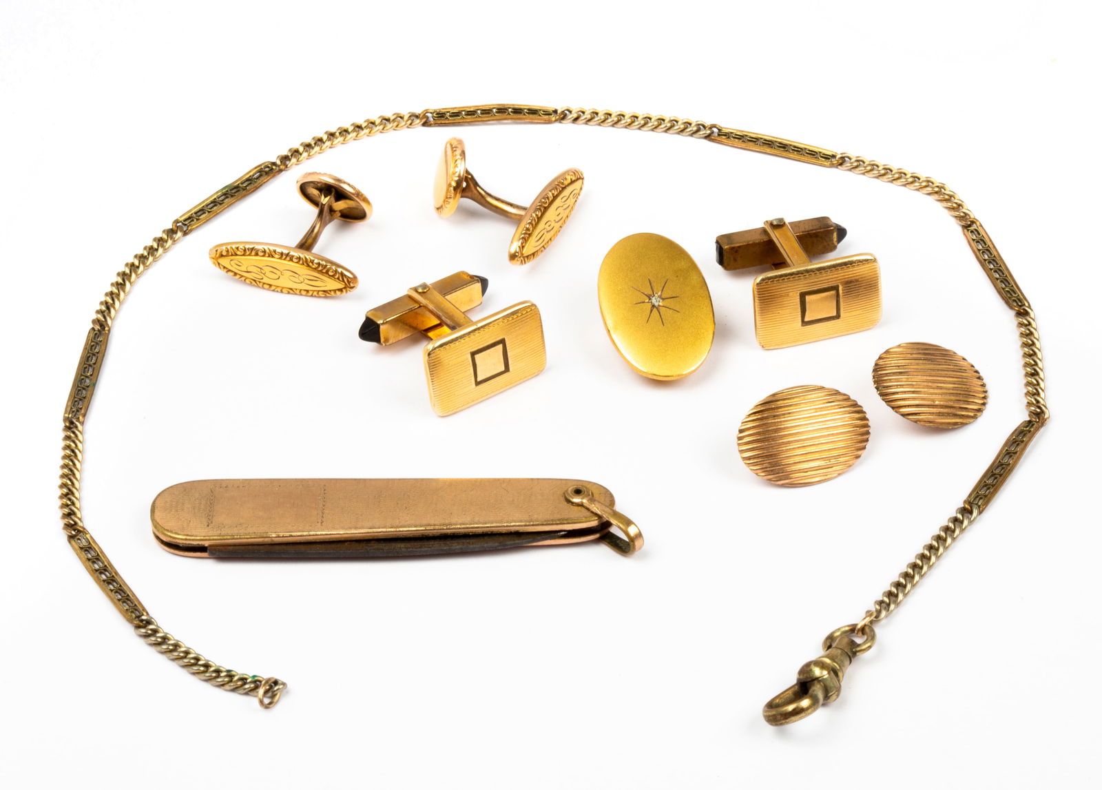 Men's Antique Gold Tone Accessories: Includes: a partially watch chain with curb and fancy links with one dog clip, tie clip with center star and diamond chip, rectangular cufflinks (some loss), ribbed oval buttons, engraved elongated ov