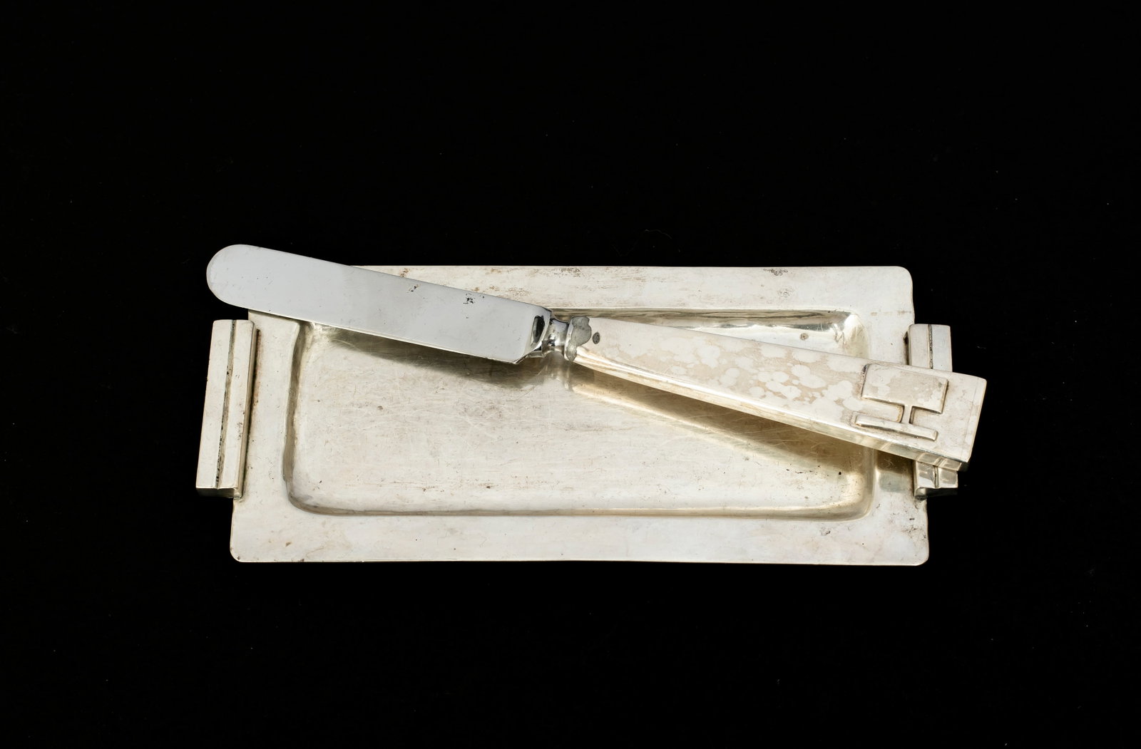 Modernist Maria Regnier Sterling Silver Butter Tray and Knife: Marked on the back of each, "MR, Sterling, Handwrought", a very heavy knife with tapered handle and the letter "H", stainless steel blade, 6 7/8", signs of solder where the ha