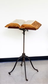 A Cast Iron and Wood Dictionary Stand with Webster's Dictionary