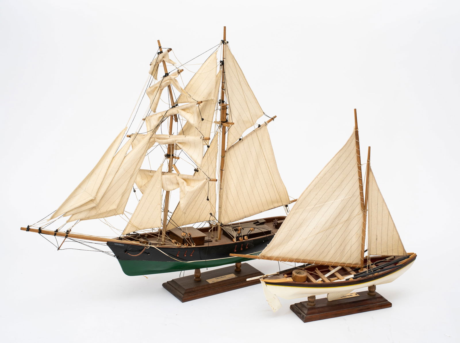 Two Model Ships by Leclerc, Quebec: The first with plaque reading, "Whaleboat 1867, H. Leclerc" and white and yellow painted hull, oars included, 14 1/2" tall on base; the second with plaque reading, "Newsboy 1854, H. Leclerc", green an