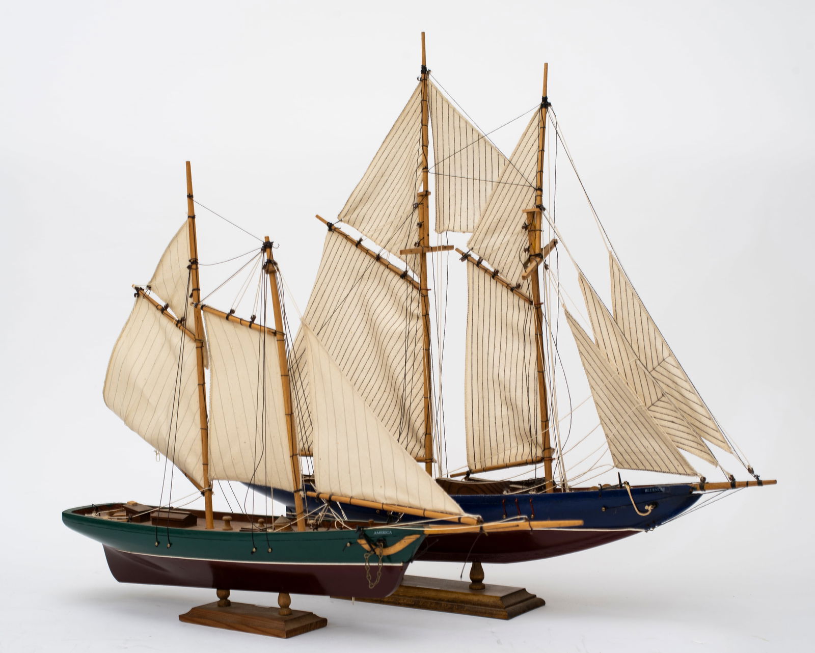 Two Ship Models by Leclerc, Quebec: The first, "America", with red and green painted hull, some loose rigging and damage, 16" tall on base; the second, "Bluenose", with red and blue painted hull, damage, areas of loss and glue from old