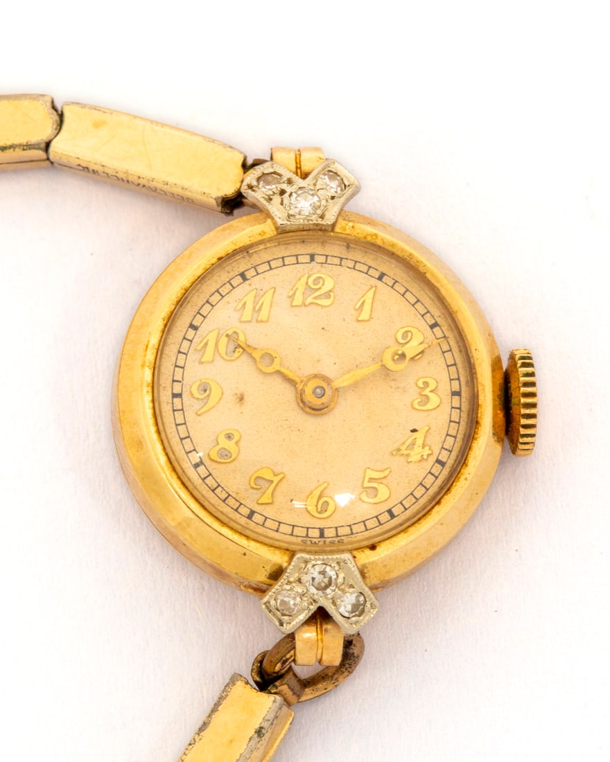 A Ladies Antique 14K and Diamond Case Watch: Marked on inside back of case "14kt solid gold", a round case with no branding on dial and gold letters, diamond studded lug, 18.7mm case, the works are Blancpain, 17 jewels, Made in Switzerland, on a