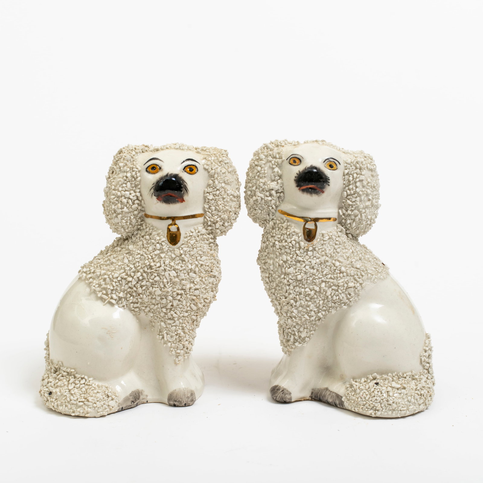 An Pair of English Staffordshire Poodle Dogs: Hand painted, with sieved clay "confetti" decoration to coats, padlock tags, marks to underside, STAFFORDSHIRE WARE ENGLAND with logo and number next to hole; each height 4 1/2&quo
