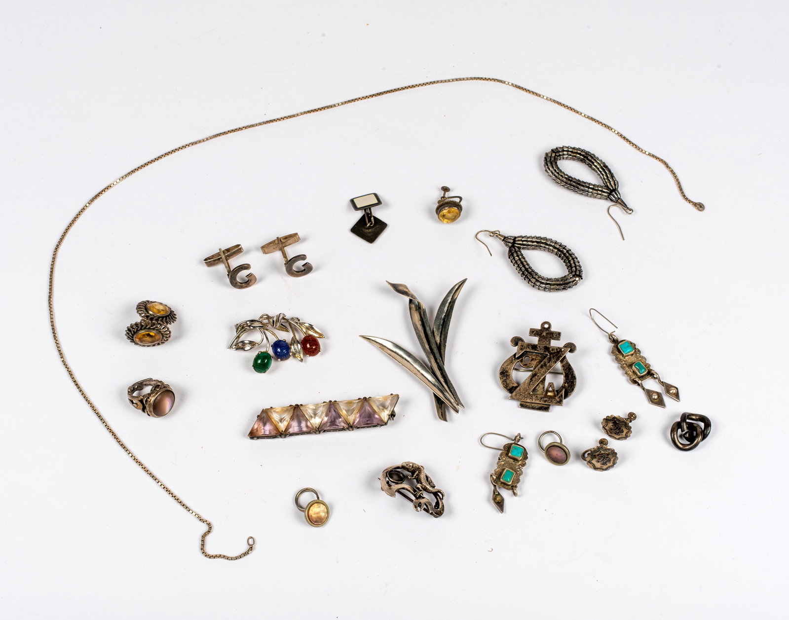 A Group of Vintage Silver and Sterling Jewelry: Includes: a marked Parenti leaf brooch; a silver tone scarab brooch; an unmarked lizard brooch missing a cabochon stone; a sterling brooch with triangular faceted clear and light purple glass, missing
