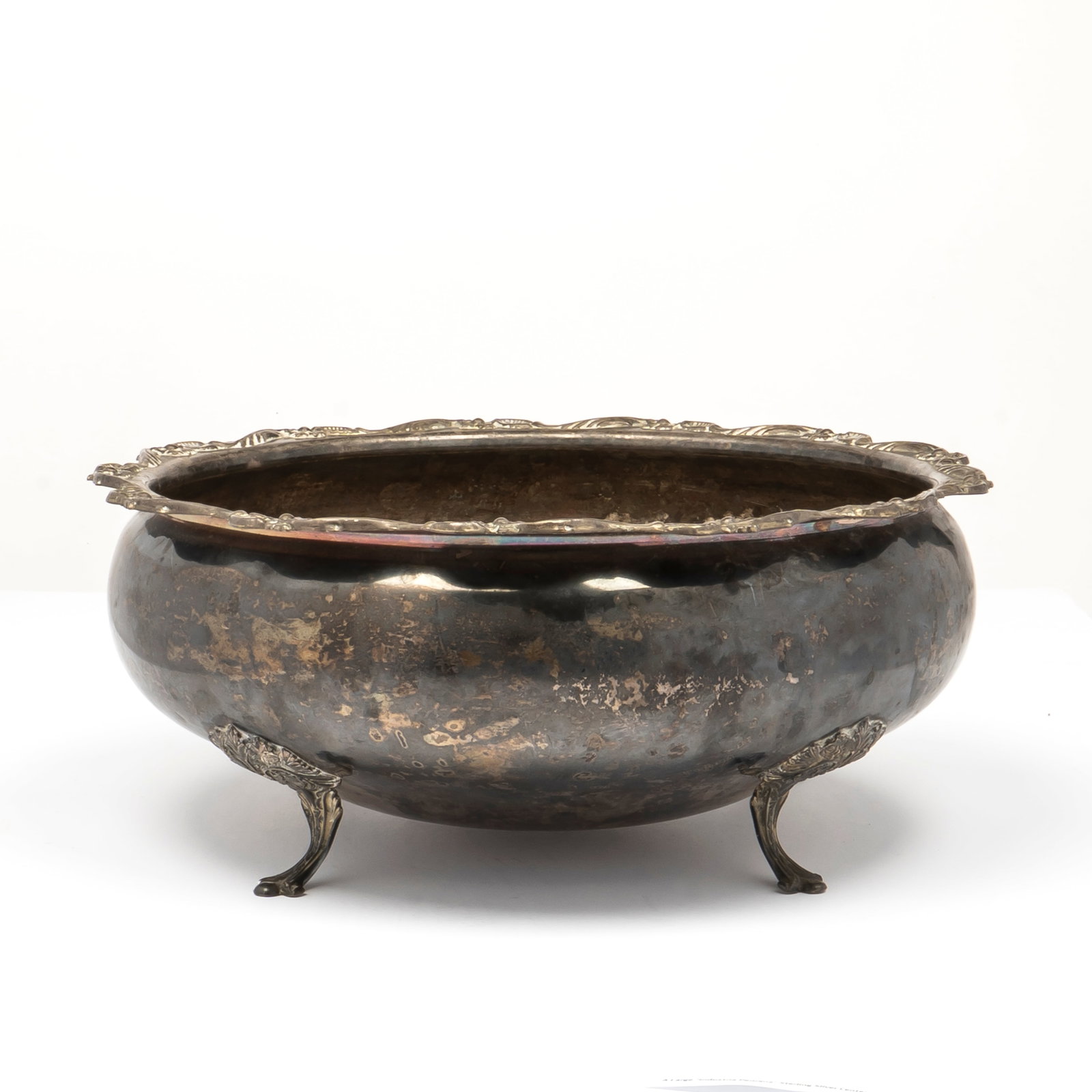 A Large "Industria Peruana" Sterling Silver Center Bowl: Marked on the bottom, " Industria Peruana, 925" with a scallop floral edge, four decorative attached feet, 11 3/4" diameter and 5" tall, a total weight of 35.1 Toz