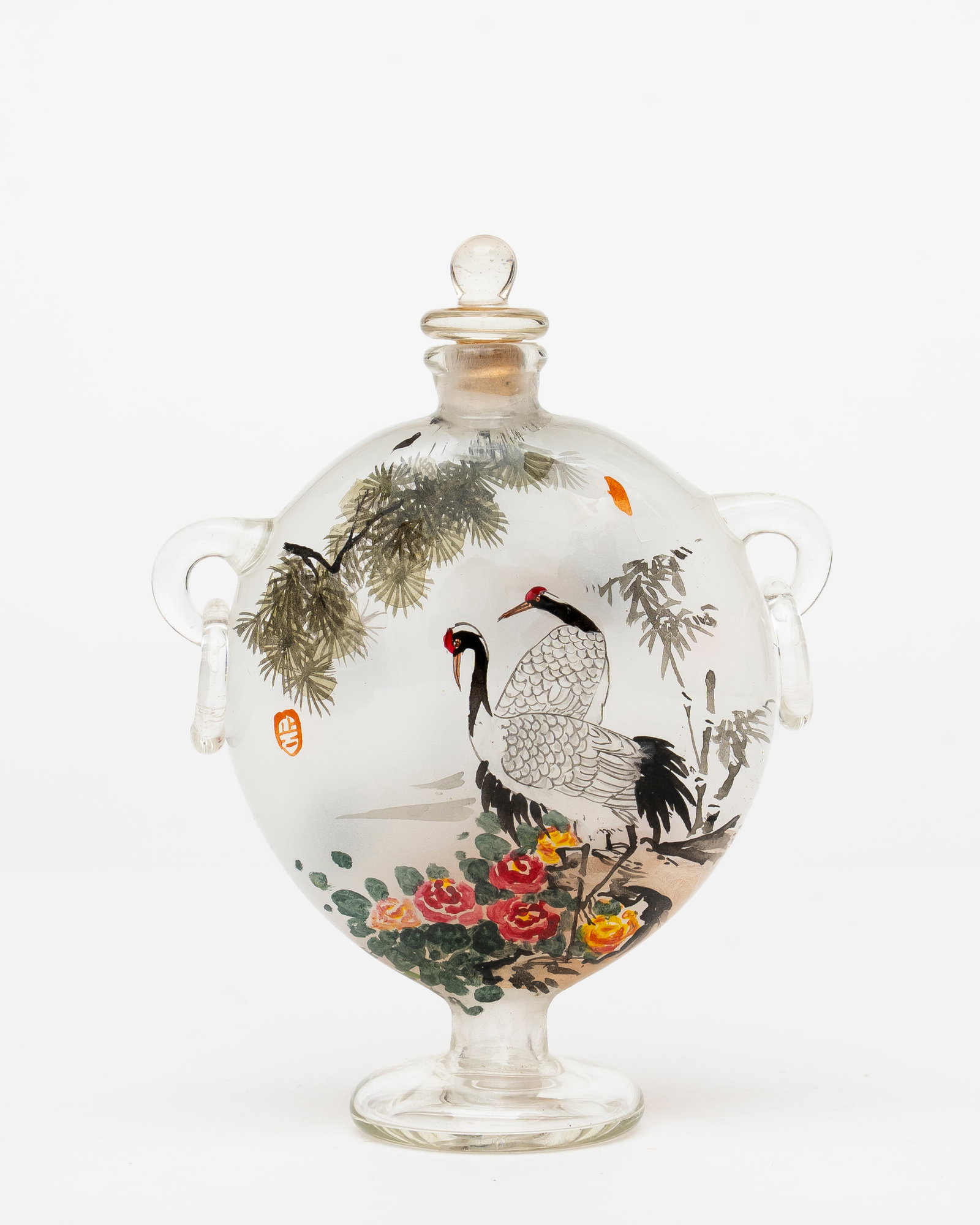 A Japanese Reverse Painted Snuff Bottle: With character mark to each side, finely done reverse paintings of red crown cranes, trees and flowers, delicate arms with attached rings, footed base and stopper, two areas of damage to the