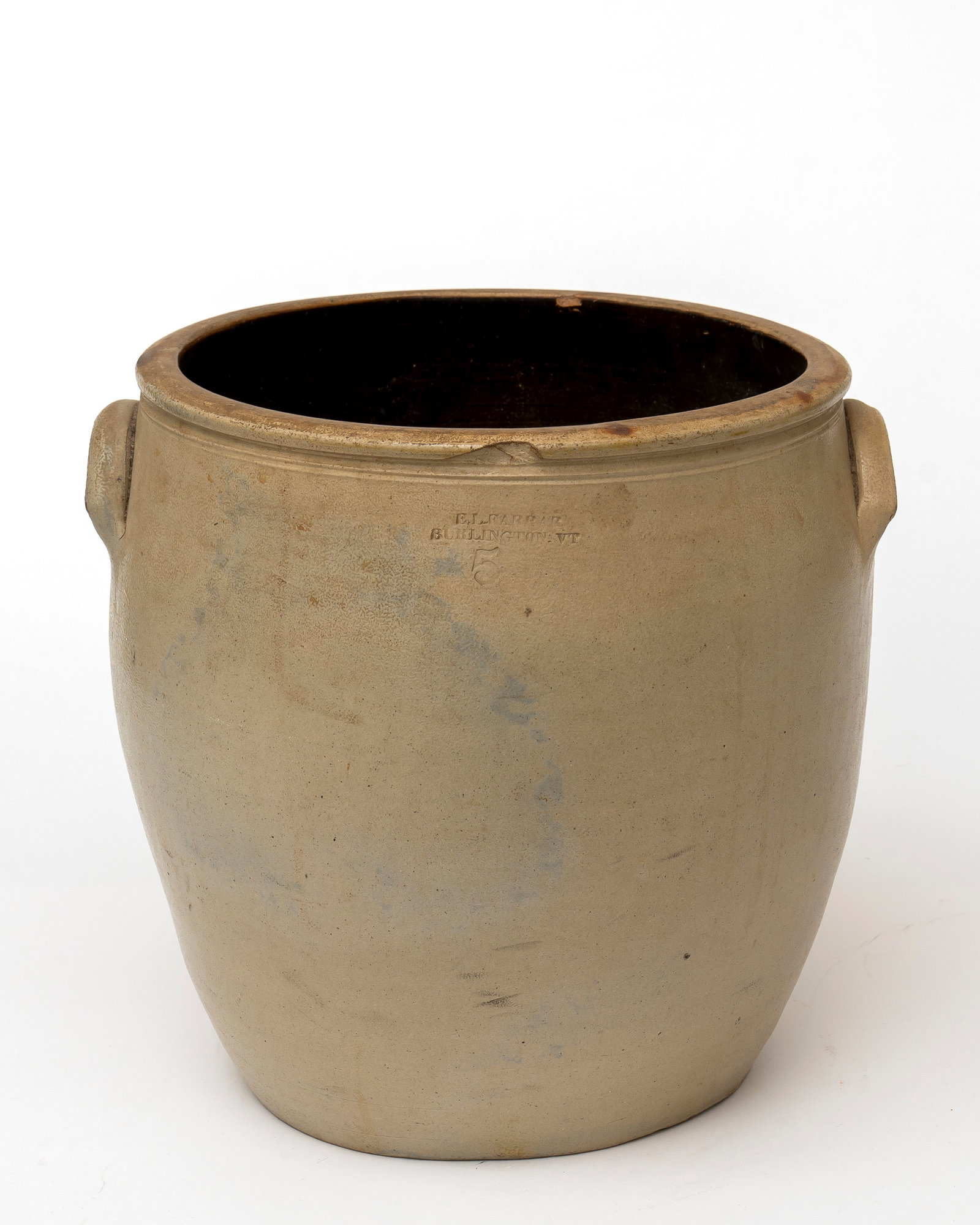 An Antique Five Gallon Stoneware Crock, E.L. Farrar, Burlington, VT: Marked on the front, "E.L. Farrar, Burlington, VT, 5", with two side handles and a tapered bottom, various chips to top edge and some burn marks, 13" tall.