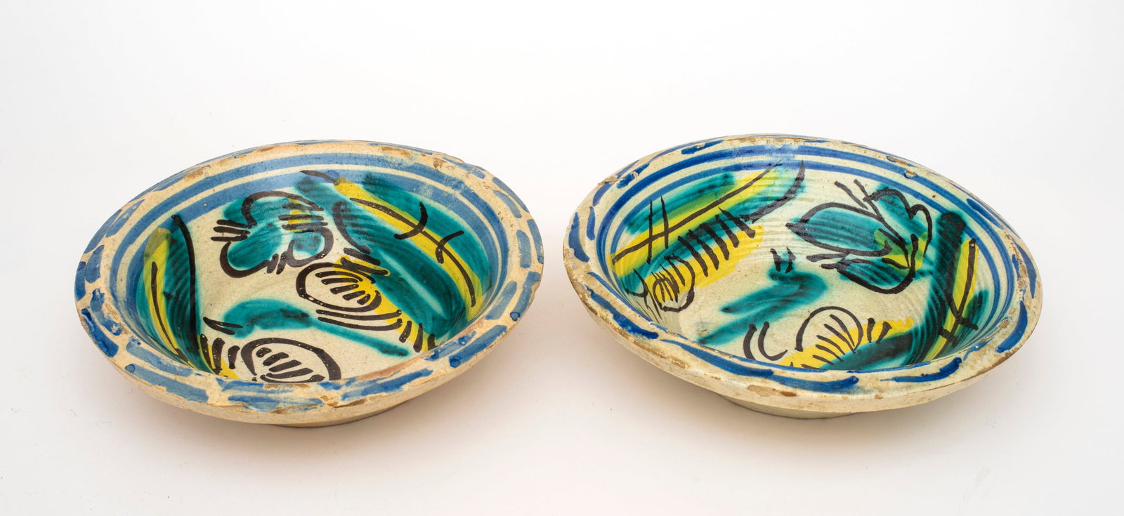 A Pair of Antique Spanish Colonial Talavera Mexico Tin Glaze Bowls: One marked SPAIN, each with stylized patters and bands of glaze in blue, yellow and green. Diameter 10 1/2". See a similar example from the same workshop, Bonhams Edinburgh, 13 December 2012, lot 473.
