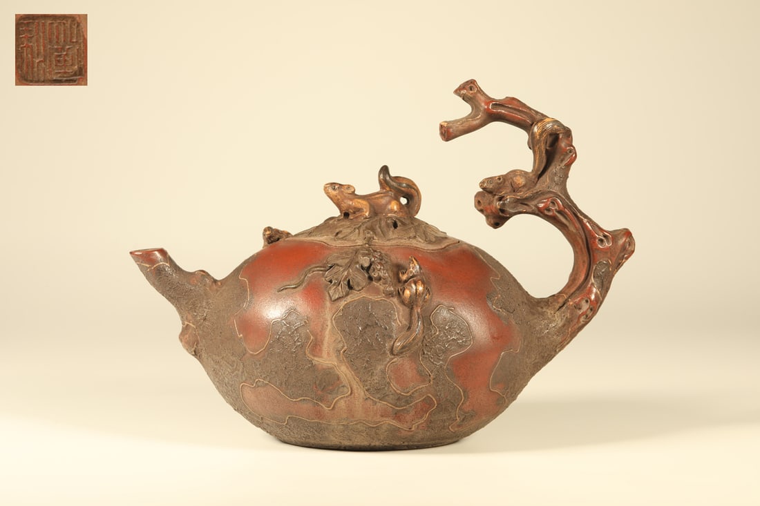 A PURPLE CLAY SQUIRREL AND GRAPE TEAPOT (REPEATED): Purple Clay Squirrel and Grape Teapot (Repeated)