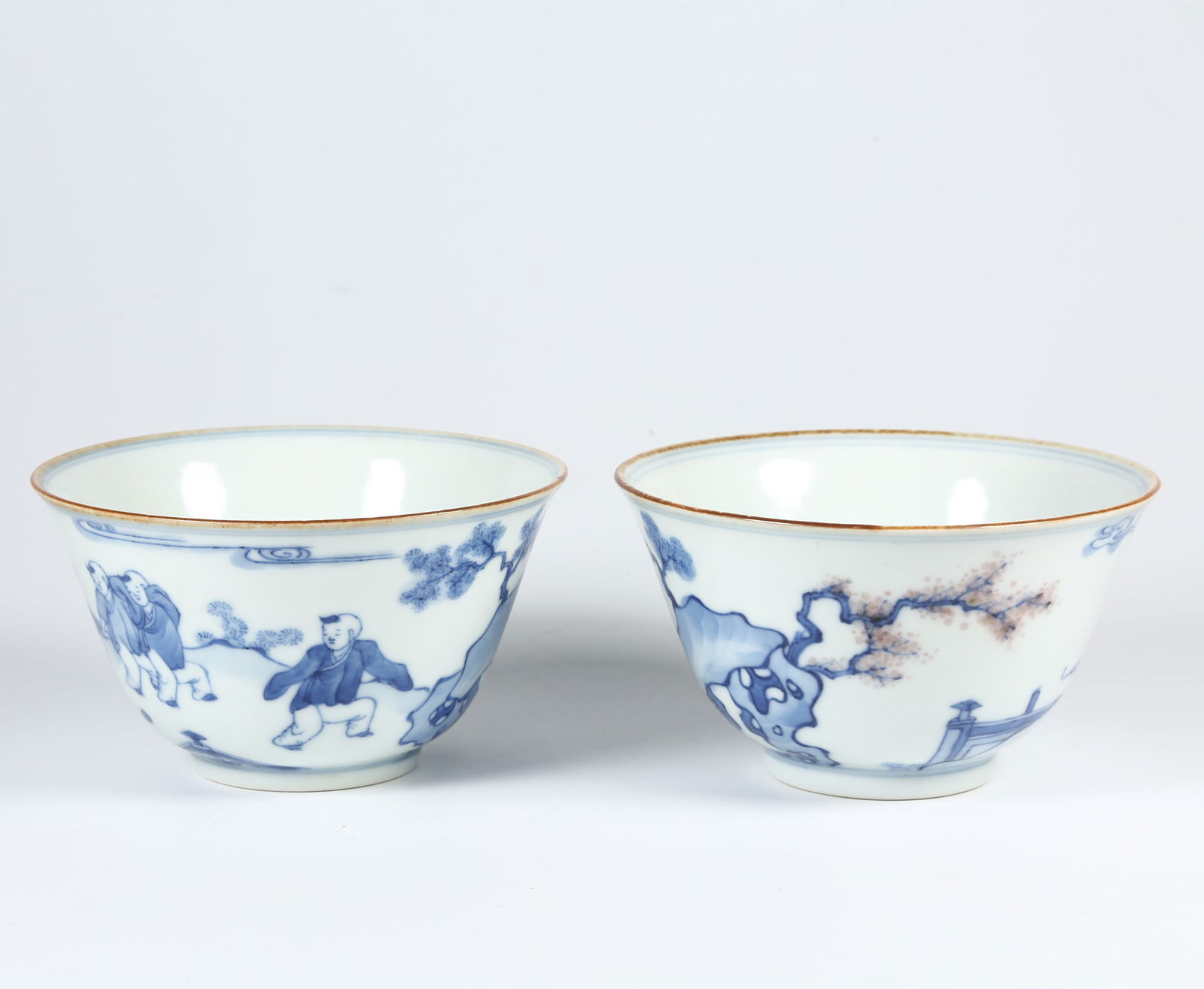 A SET OF BLUE AND WHITE AND UNDERGLAZE RED CUPS WITH CHILDREN AT PLAY MOTIF: Set of Blue and White and Underglaze Red Cups with Children at Play Motif