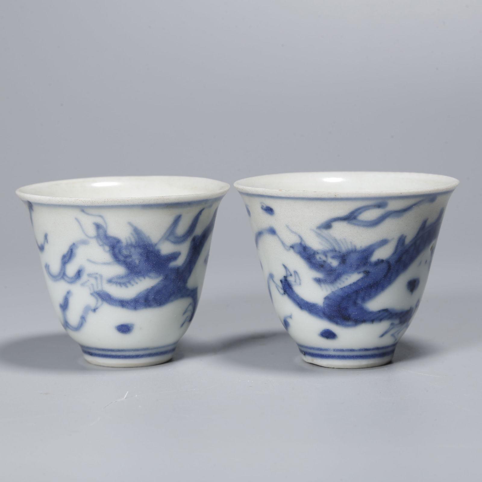 A PAIR OF BLUE AND WHITE CUPS WITH DRAGON DESIGN: Pair of Blue and White Cups with Dragon Design