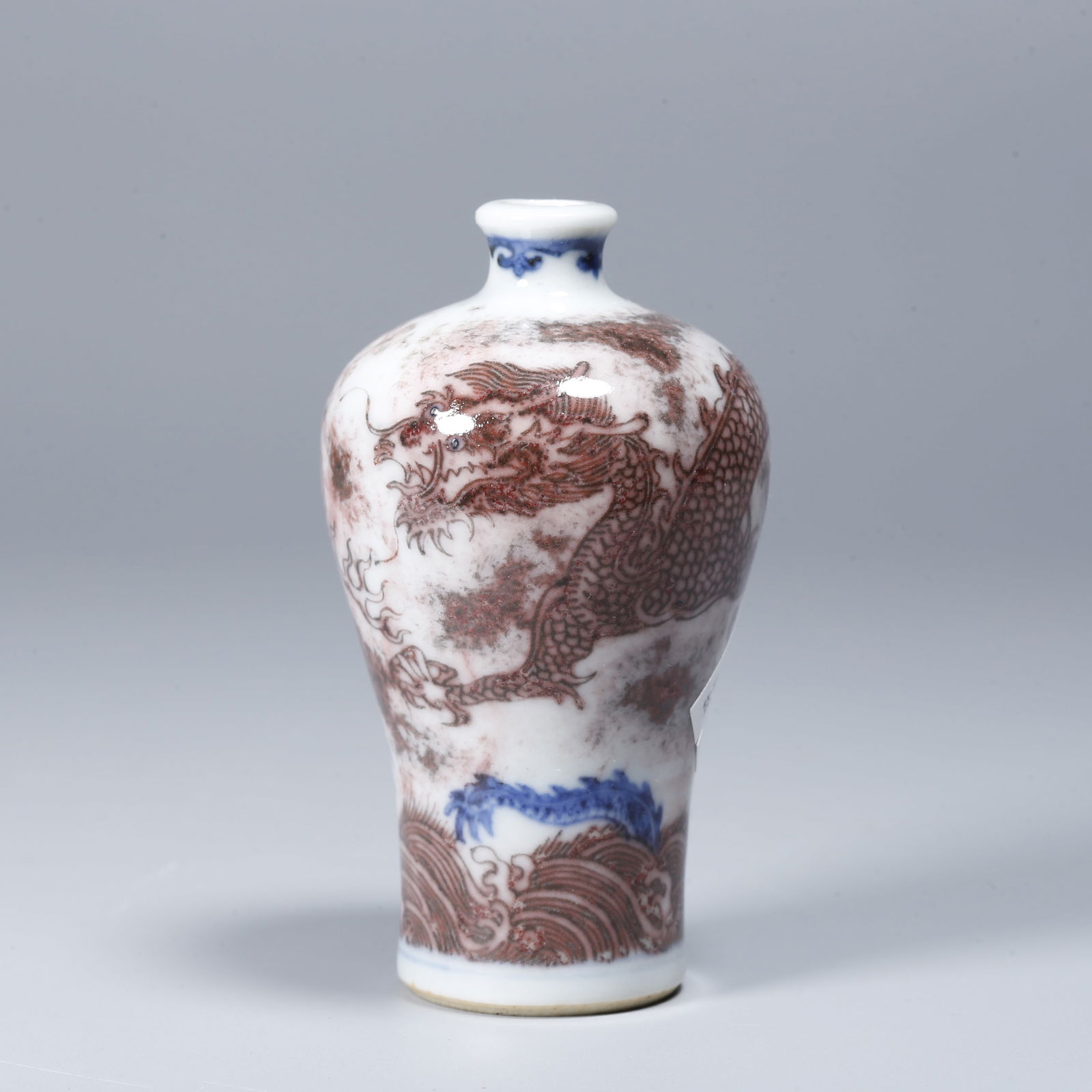 A BLUE AND WHITE UNDERGLAZE RED SNUFF BOTTLE WITH MARINE DRAGON DESIGN: Blue and White Underglaze Red Snuff Bottle with Marine Dragon Design