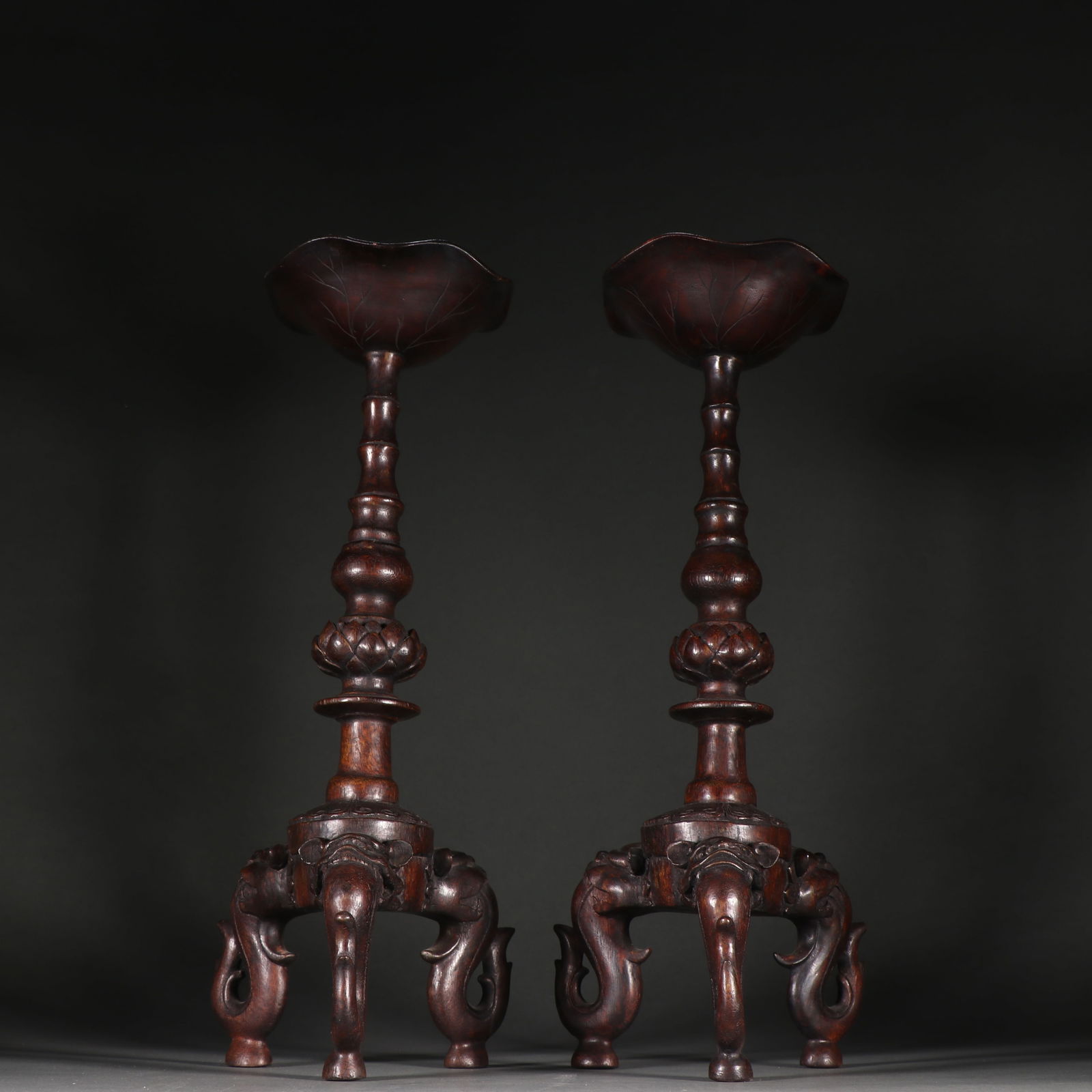 A PAIR OF AGARWOOD LOTUS THREE-FOOTED BEAST-HEAD CANDLESTICKS: Pair of agarwood lotus three-footed beast-head candlesticks