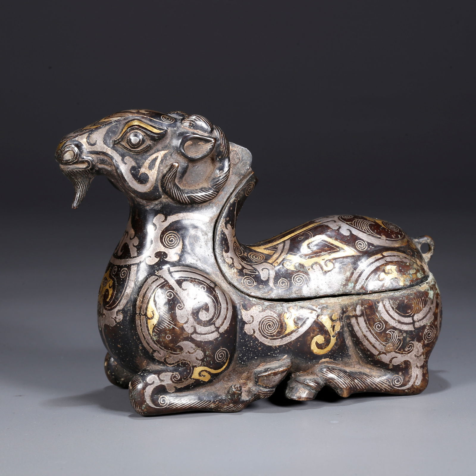 A BRONZE INLAID WITH GOLD AND SILVER SHEEP-SHAPED CANDLESTICK: Bronze Inlaid with Gold and Silver Sheep-Shaped Candlestick