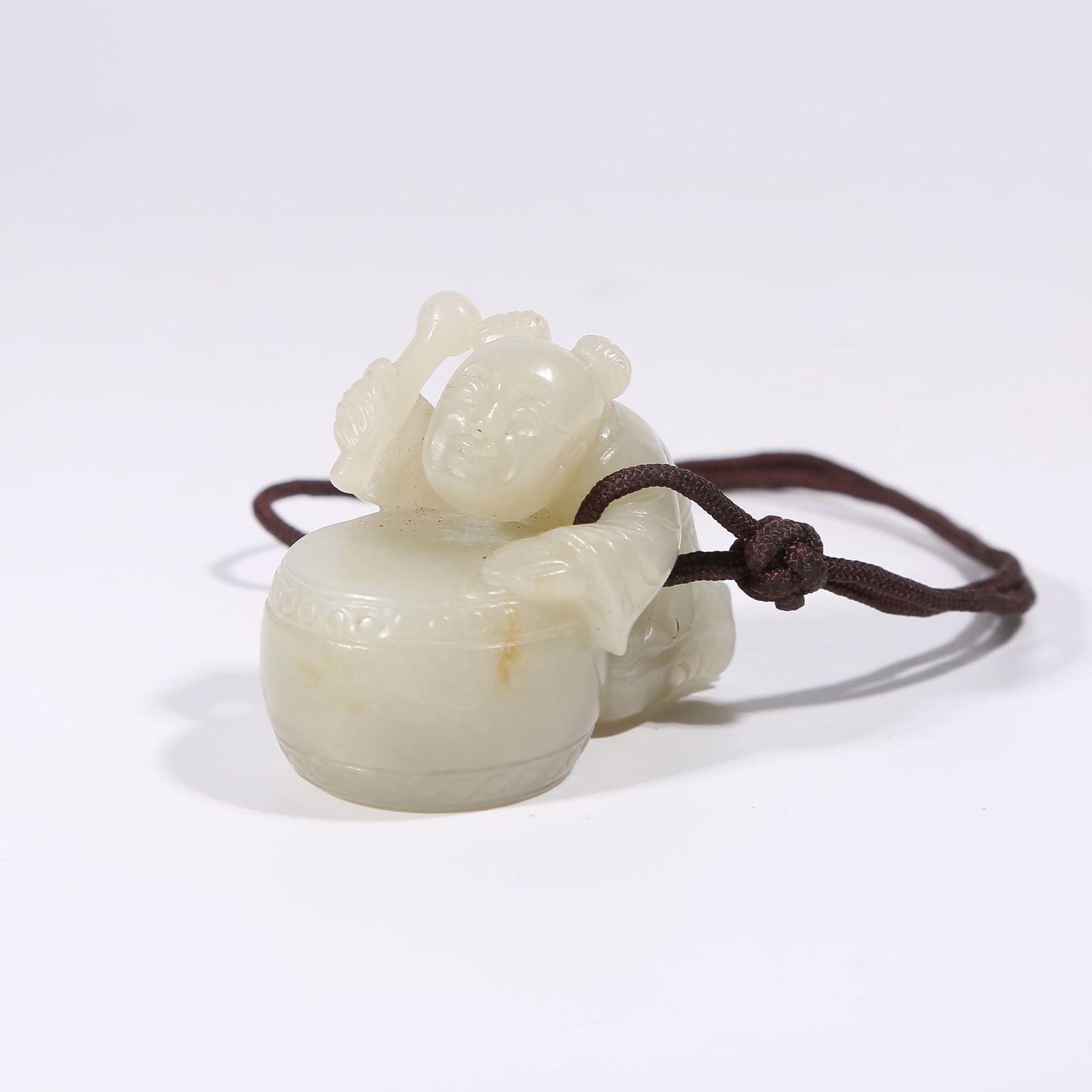A HETIAN JADE DRUM-PLAYING BOY PENDANT: Hetian Jade Drum-Playing Boy Pendant
