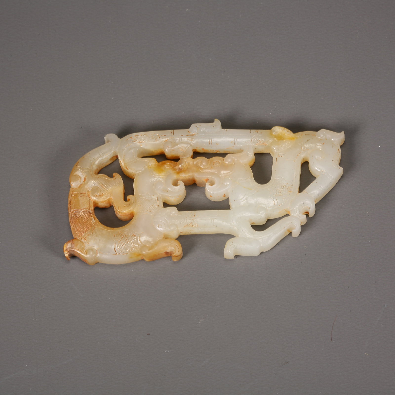 A ANCIENT JADE DOUBLE-DRAGON PENDANT: Ancient jade double-dragon pendant