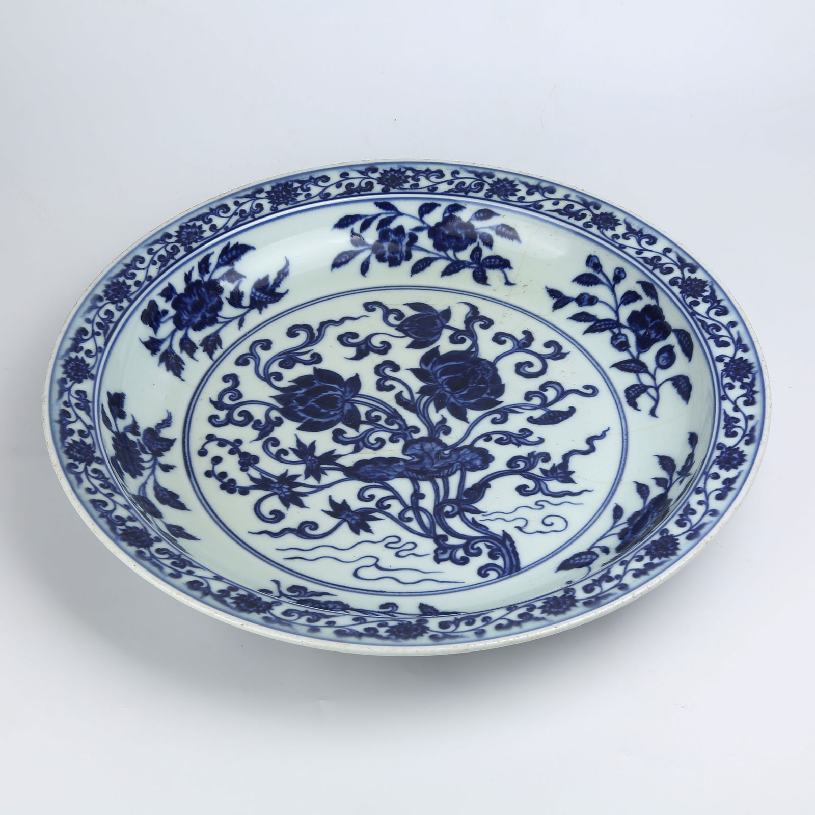 A BLUE AND WHITE LARGE FOLDED-RIM PLATE WITH LOTUS BUNDLE DESIGN (1 of 9)