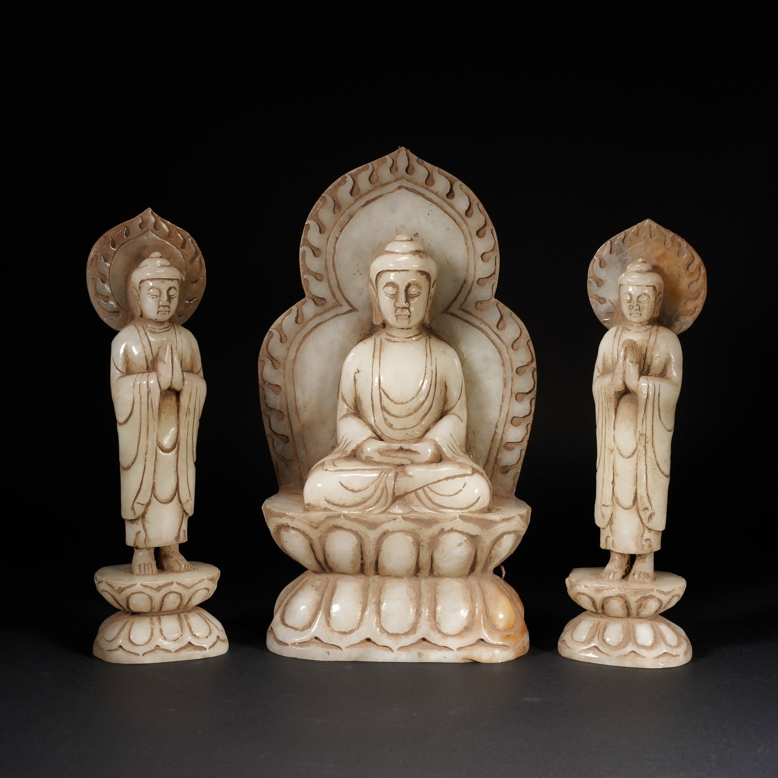 A A GROUP OF THREE HETIAN JADE BUDDHAS (THREE JEWELS), TANG DYNASTY: A group of three Hetian jade Buddhas (Three Jewels), Tang Dynasty