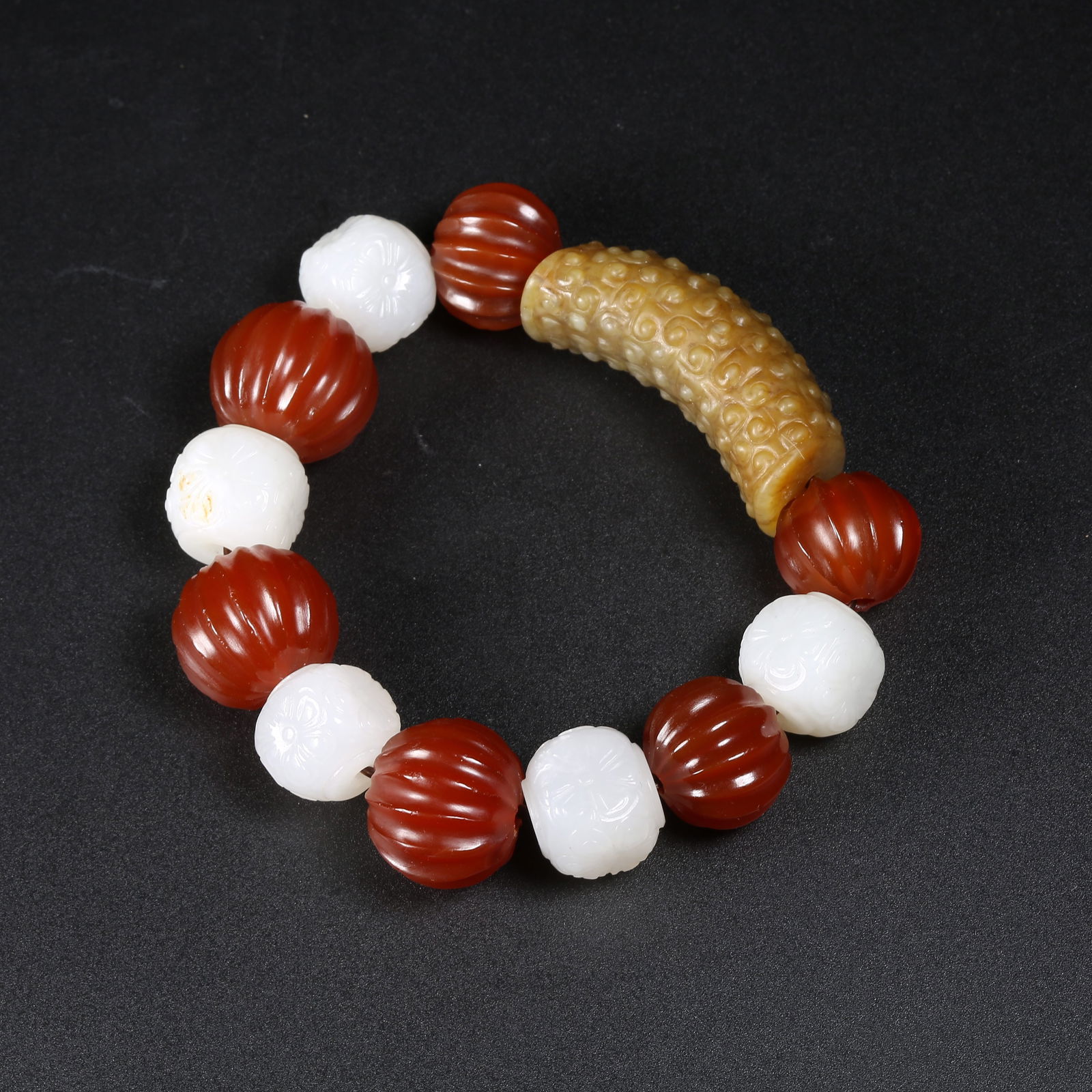 A HETIAN JADE "RU-DING" PATTERNED LEZI HAND-STRUNG BRACELET: Hetian jade "ru-ding" patterned lezi hand-strung bracelet