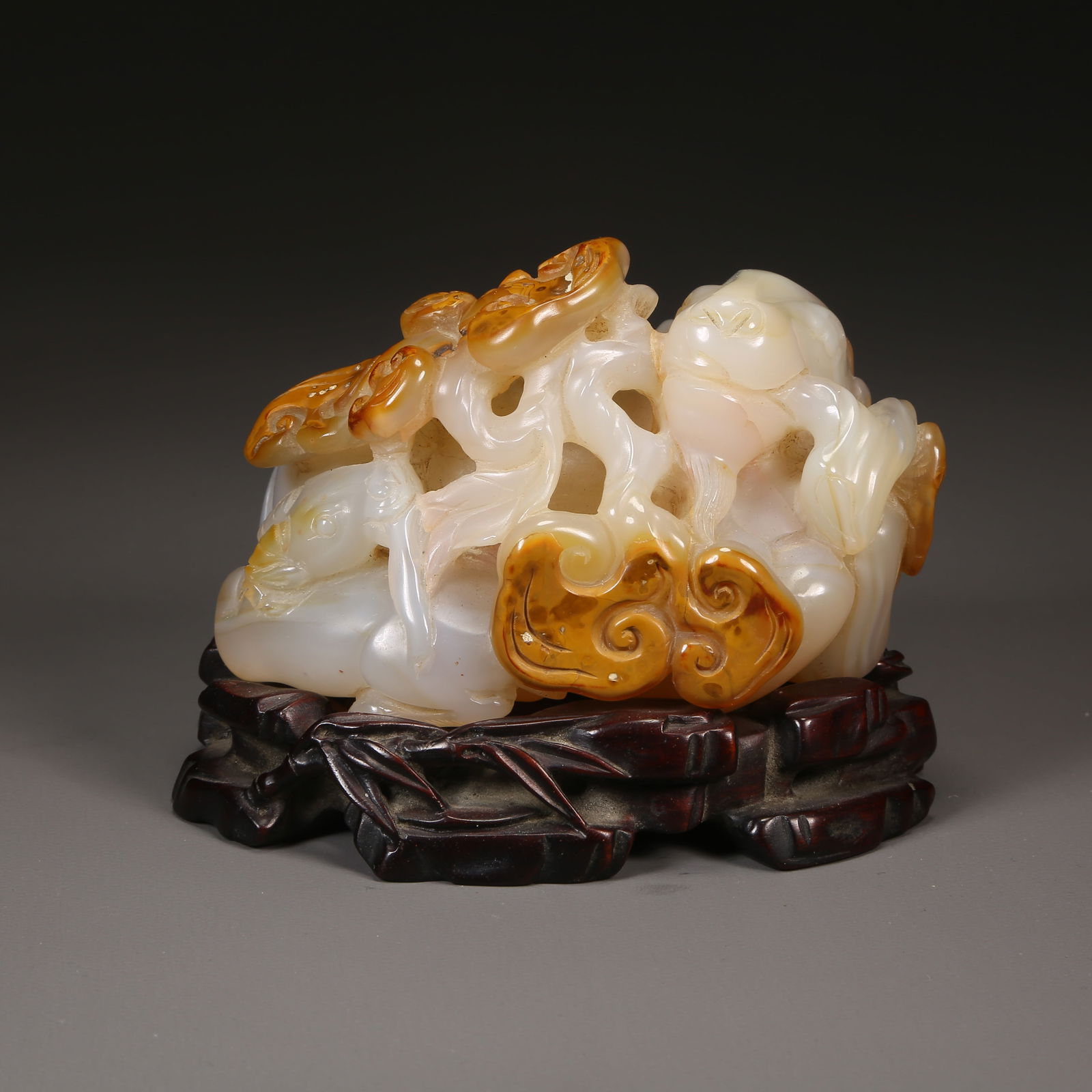 A AGATE ORNAMENT OF A SPIRITUAL RAM HOLDING A LINGZHI SPRIG (1 of 8)