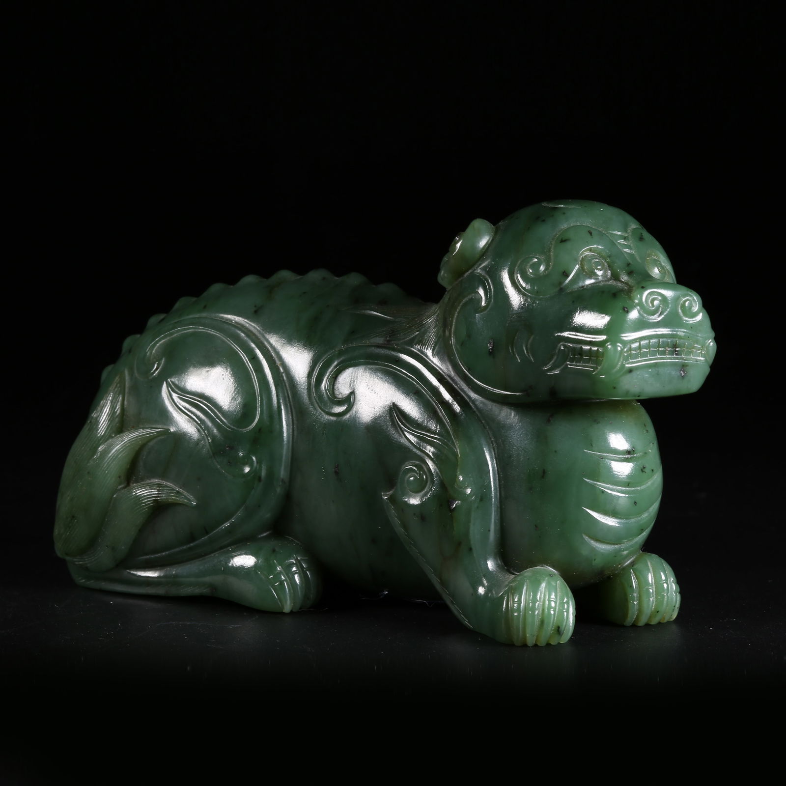 A HETIAN GREEN JADE AUSPICIOUS BEAST ORNAMENT: Hetian green jade auspicious beast ornament