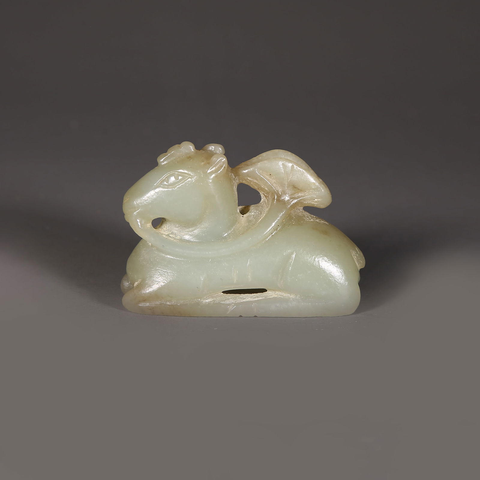 A HETIAN JADE MYTHICAL BEAST HOLDING LOTUS LEAF PENDANT: Hetian jade mythical beast holding lotus leaf pendant