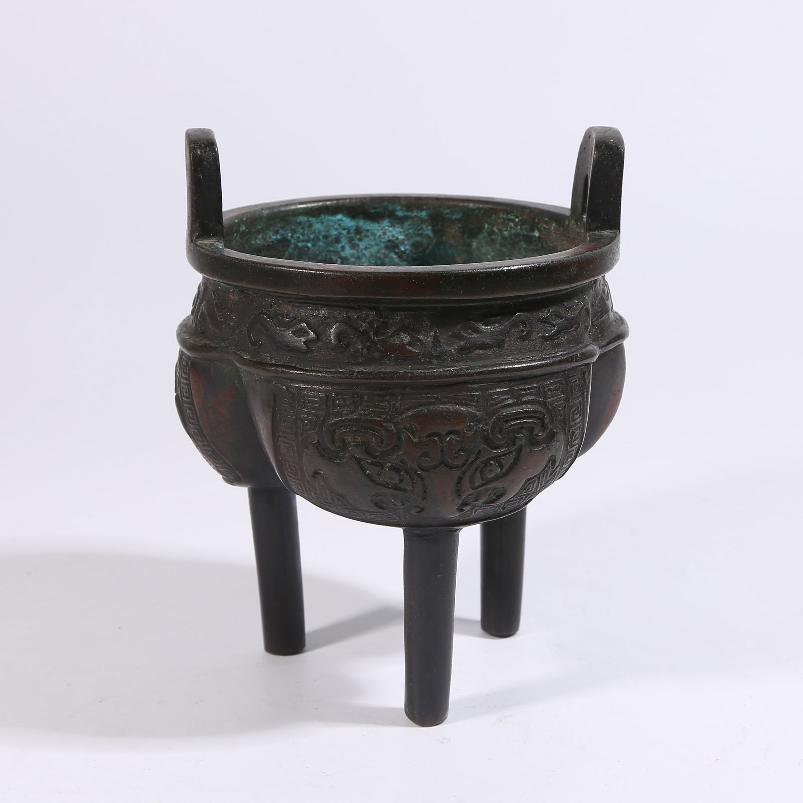 A BRONZE DING-STYLE CENSER WITH TAOTIE MASK DESIGN: Bronze ding-style censer with taotie mask design