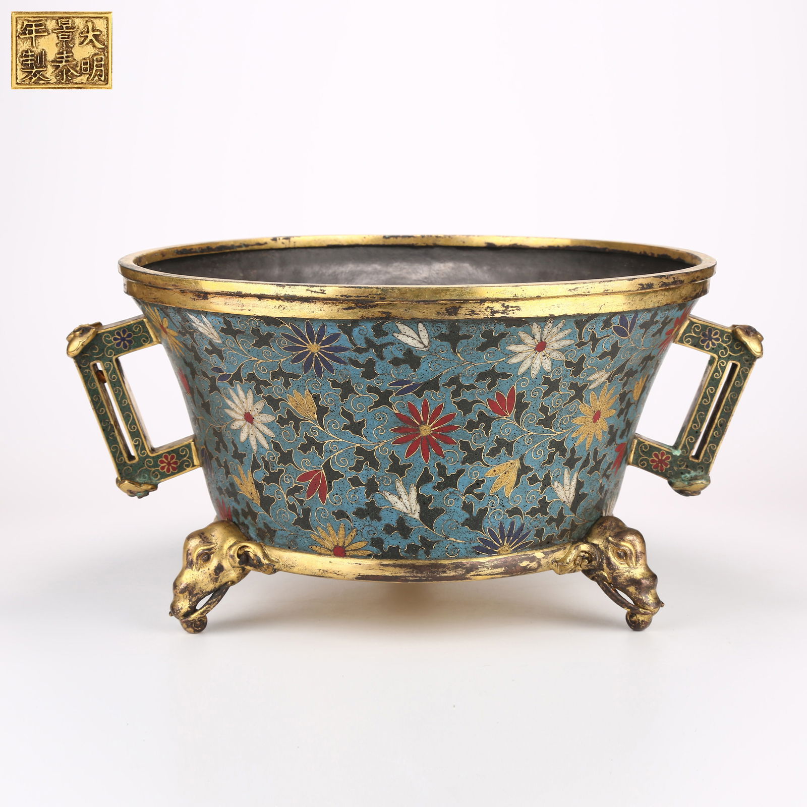 A CLOISONNÉ ENAMEL TRIPOD CENSER WITH INTERTWINED FLORAL DESIGN, HALBERD-SHAPED HANDLES, AND: Cloisonné enamel tripod censer with intertwined floral design, halberd-shaped handles, and elephant-trunk legs