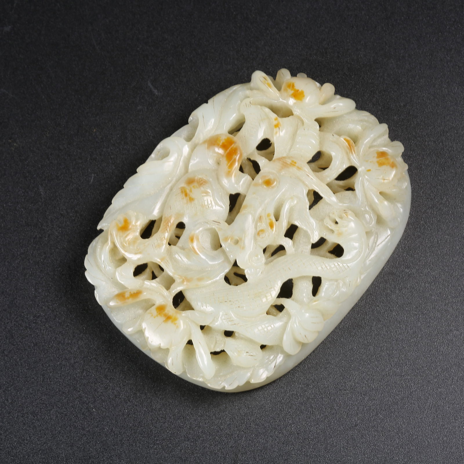 A HETIAN JADE PENDANT WITH PIERCED FLORAL AND DRAGON MOTIF: Hetian Jade Pendant with Pierced Floral and Dragon Motif