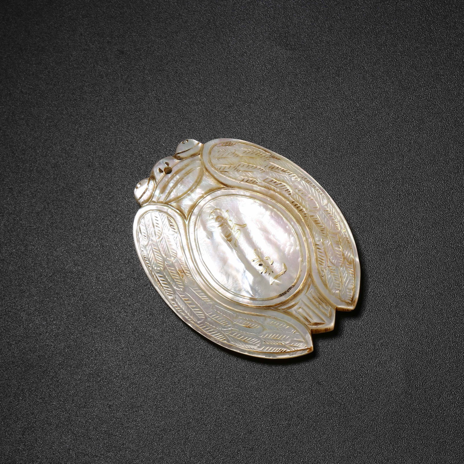 A MOTHER-OF-PEARL INLAID CICADA SHAPED ABSTINENCE PLAQUE: Mother-of-Pearl Inlaid Cicada Shaped Abstinence Plaque