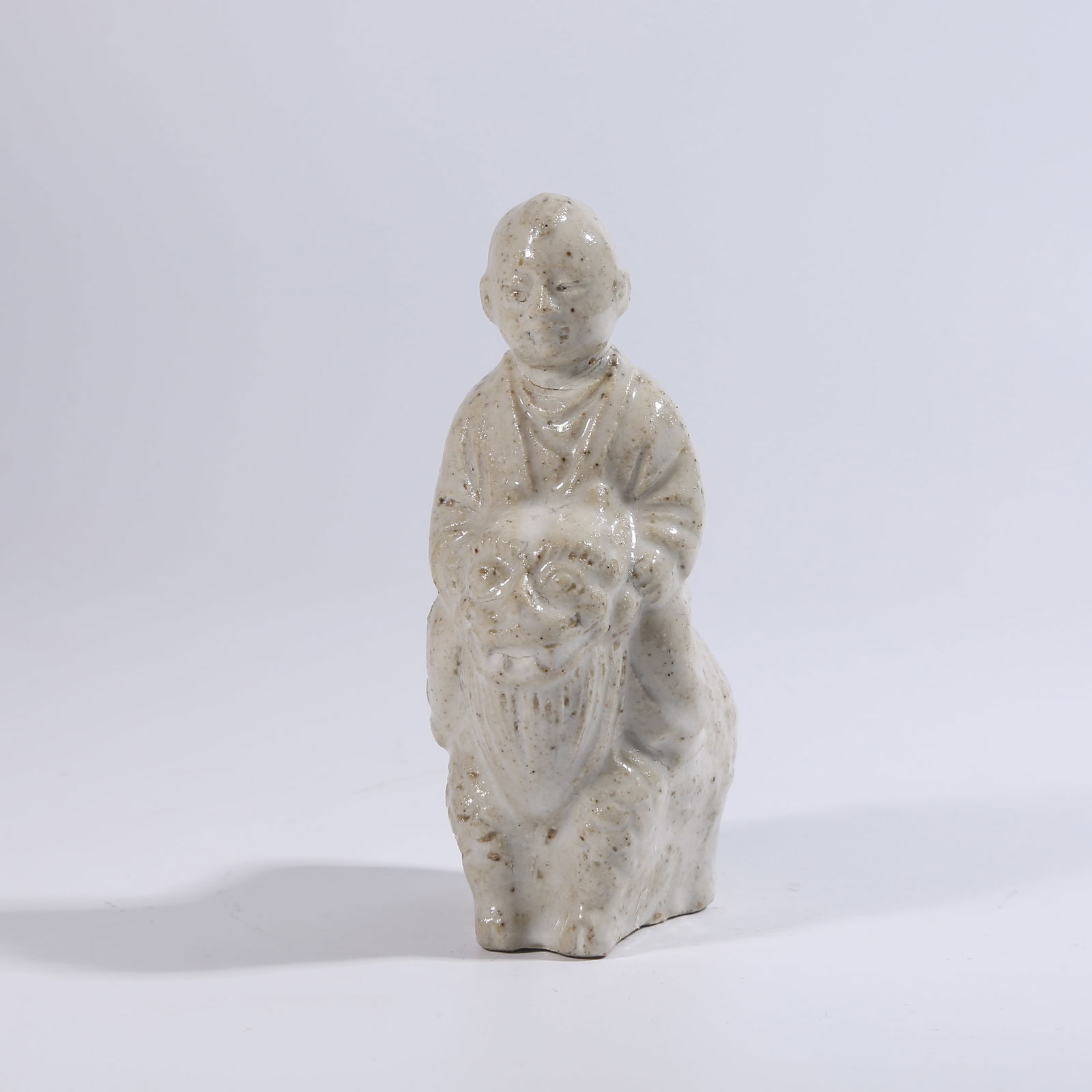 A DING WARE FIGURINE OF A CHILD PLAYING WITH BEASTS (1 of 8)