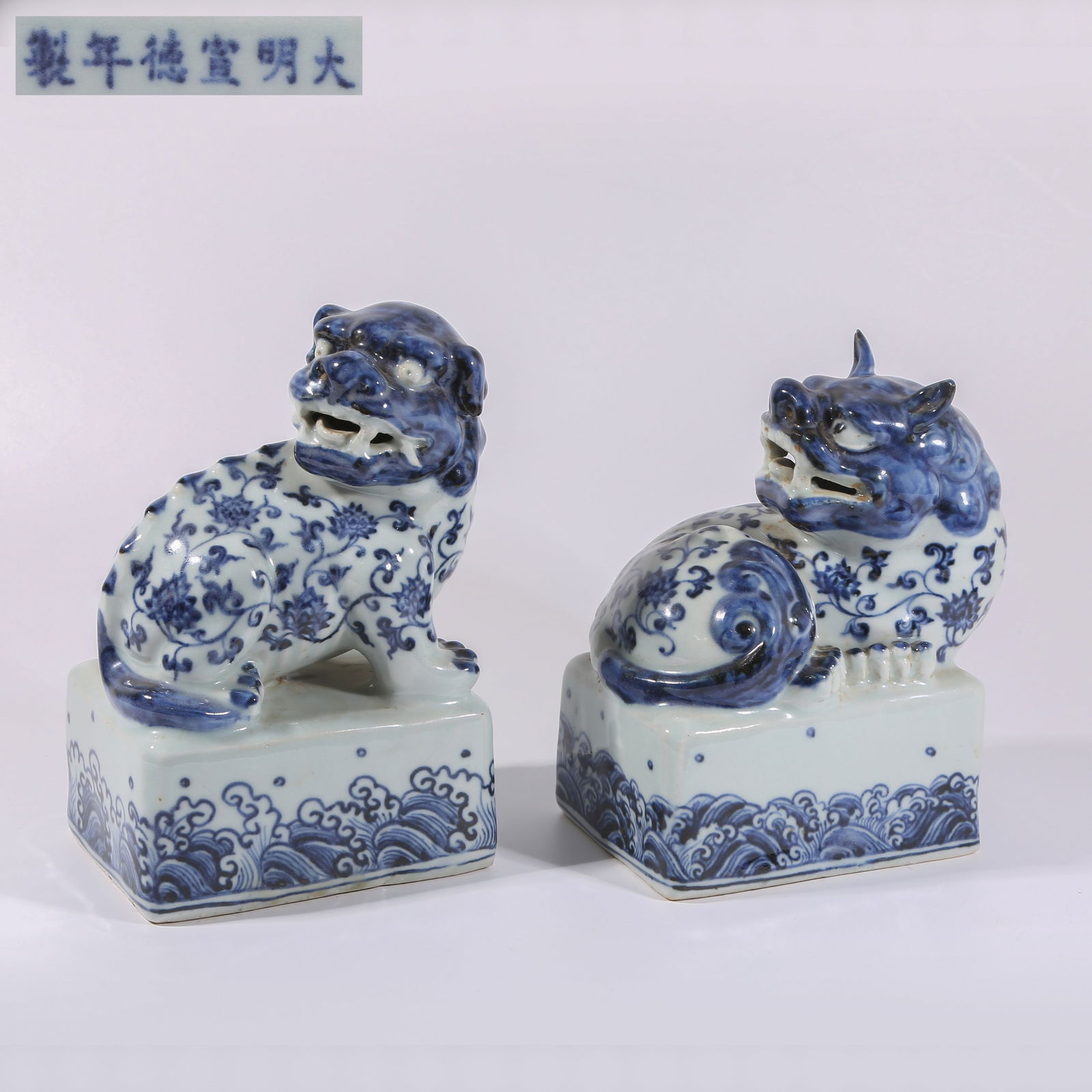 A SET OF BLUE-AND-WHITE SCROLLING LOTUS LION PAPERWEIGHTS: Set of blue-and-white scrolling lotus lion paperweights