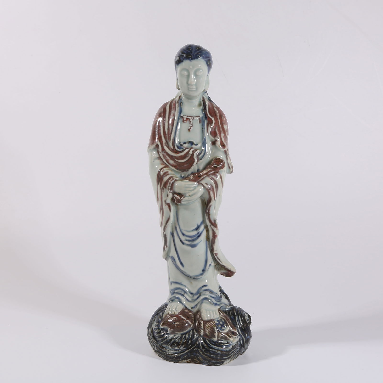 A BLUE-AND-WHITE AND UNDERGLAZE-RED GUANYIN FIGURE (1 of 9)