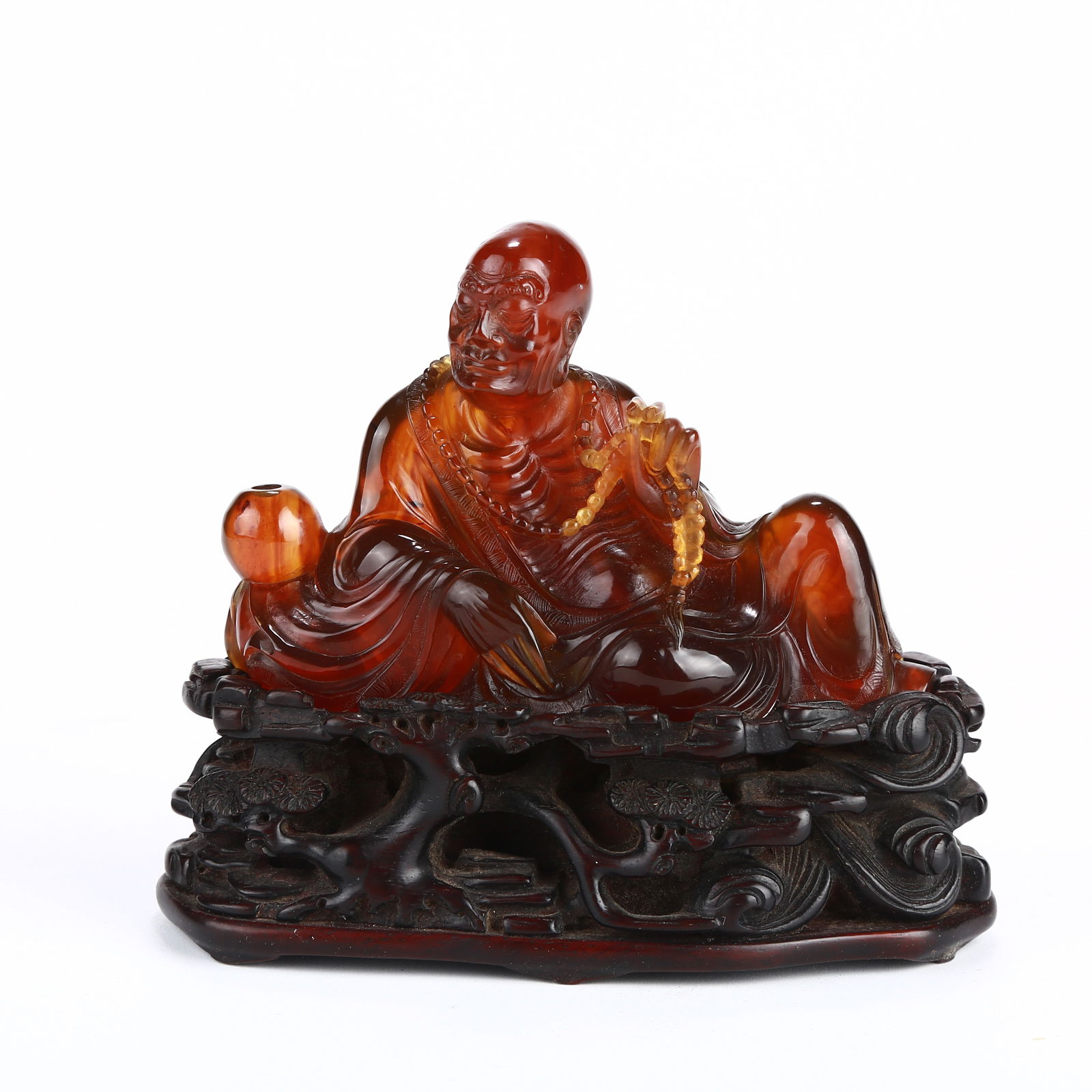 A AMBER FIGURINE OF AN ARHAT: Amber figurine of an arhat