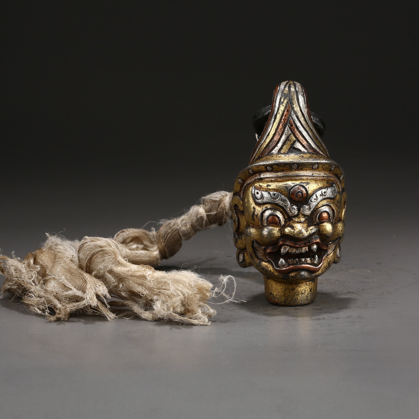 A RED BRONZE PENDANT WITH GILDED AND SILVER INLAID BUDDHA HEAD (1 of 10)